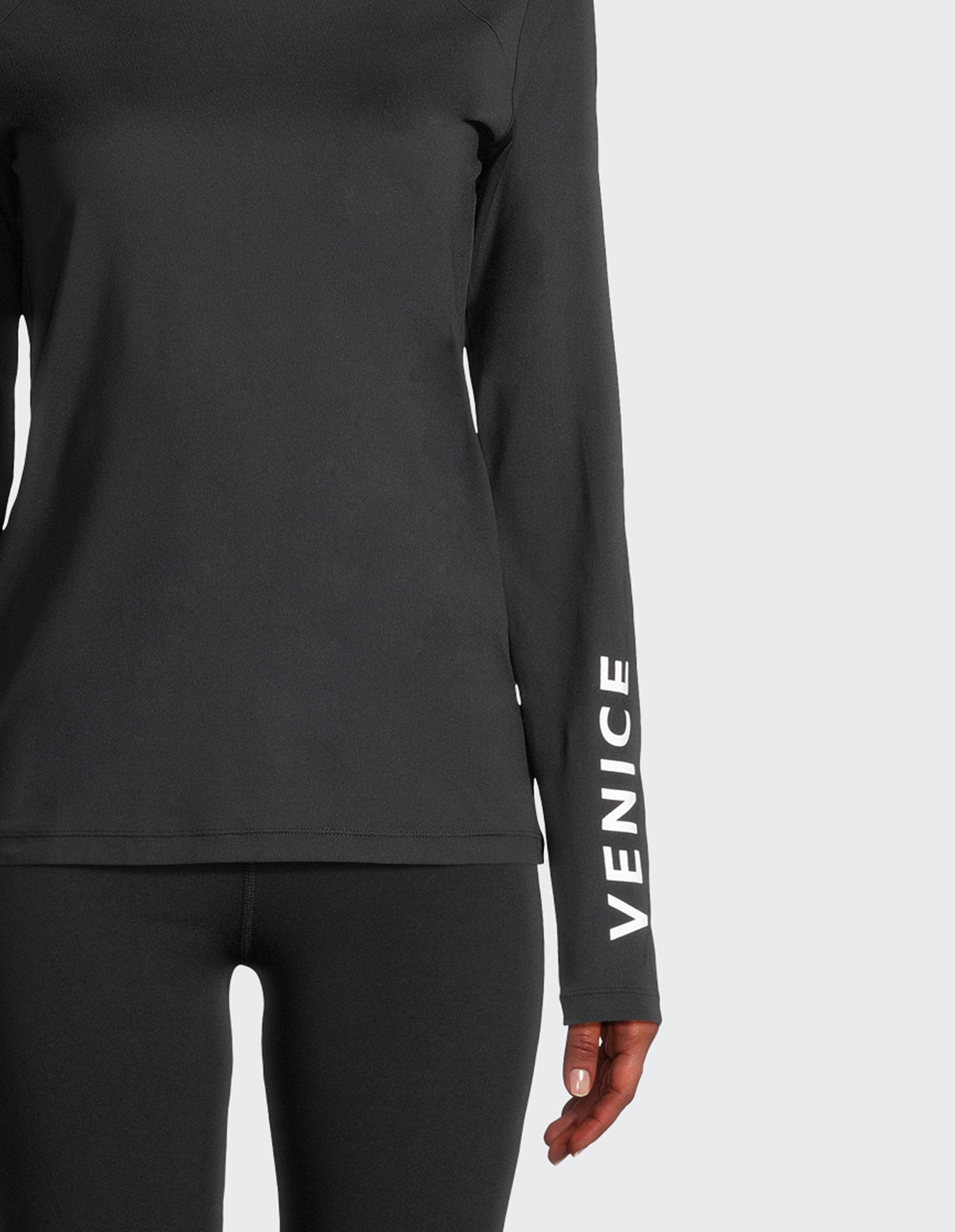 Schwarzes, langärmliges Leana-Hemd von Venice Beach mit weißem Logo auf dem Ärmel.
