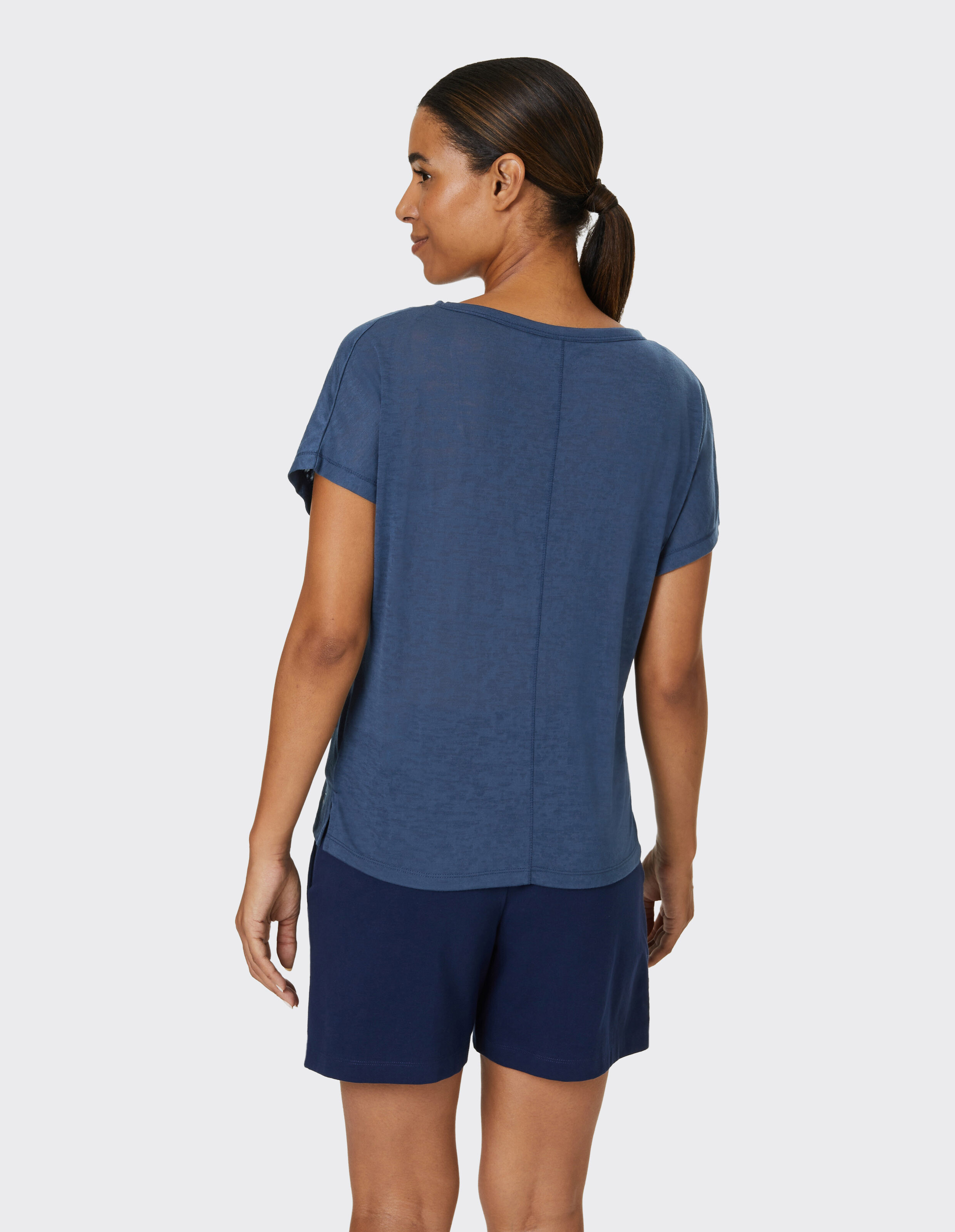 Frau trägt ein marineblaues Freizeitoberteil und Shorts und zeigt entspannten Stil.