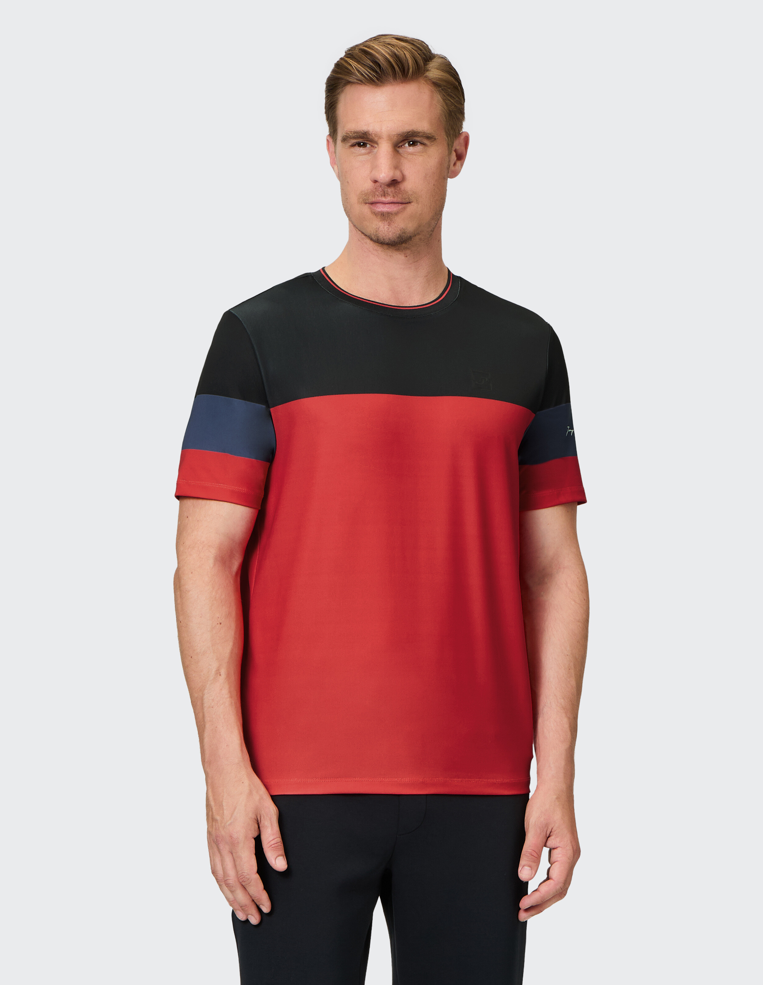 Mann trägt ein lässiges T-Shirt in den Farben Rot, Schwarz und Blau für den täglichen Gebrauch.