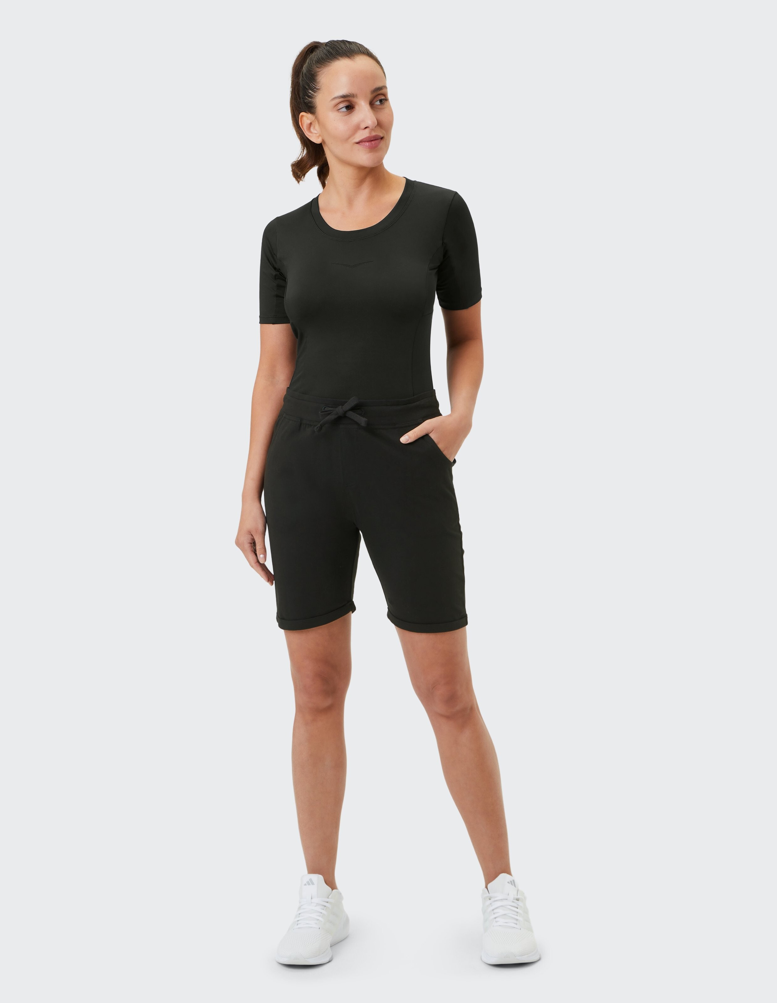 Frau trägt schwarze Carlotti-Shorts von Venice Beach und ein passendes T-Shirt.