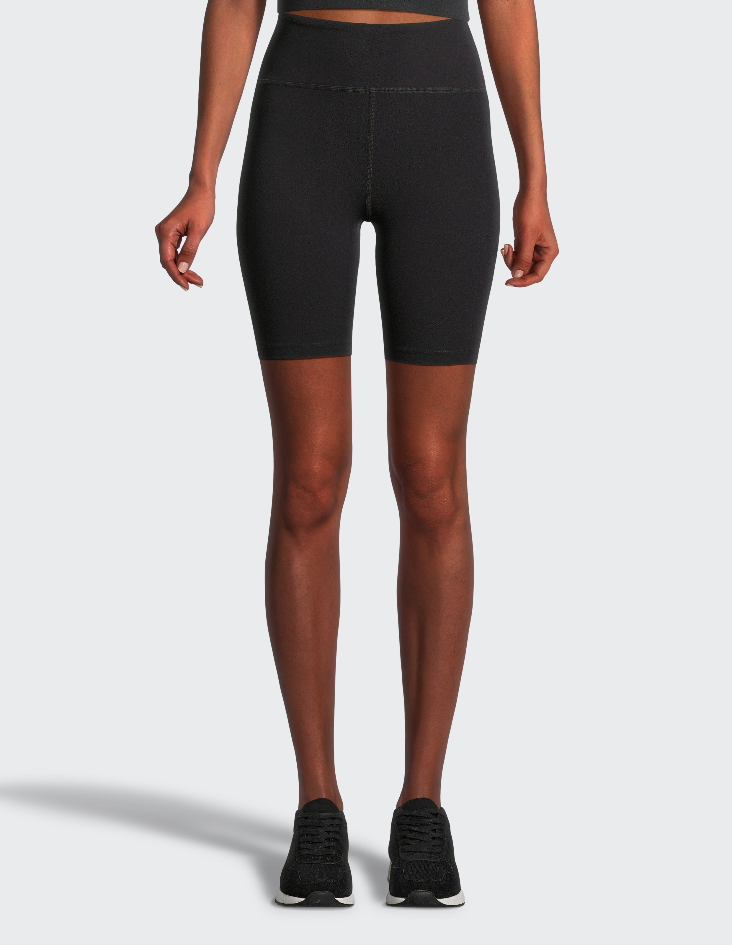Frau trägt schwarze Bikershorts mit hoher Taille für lässige, bequeme Loungewear.