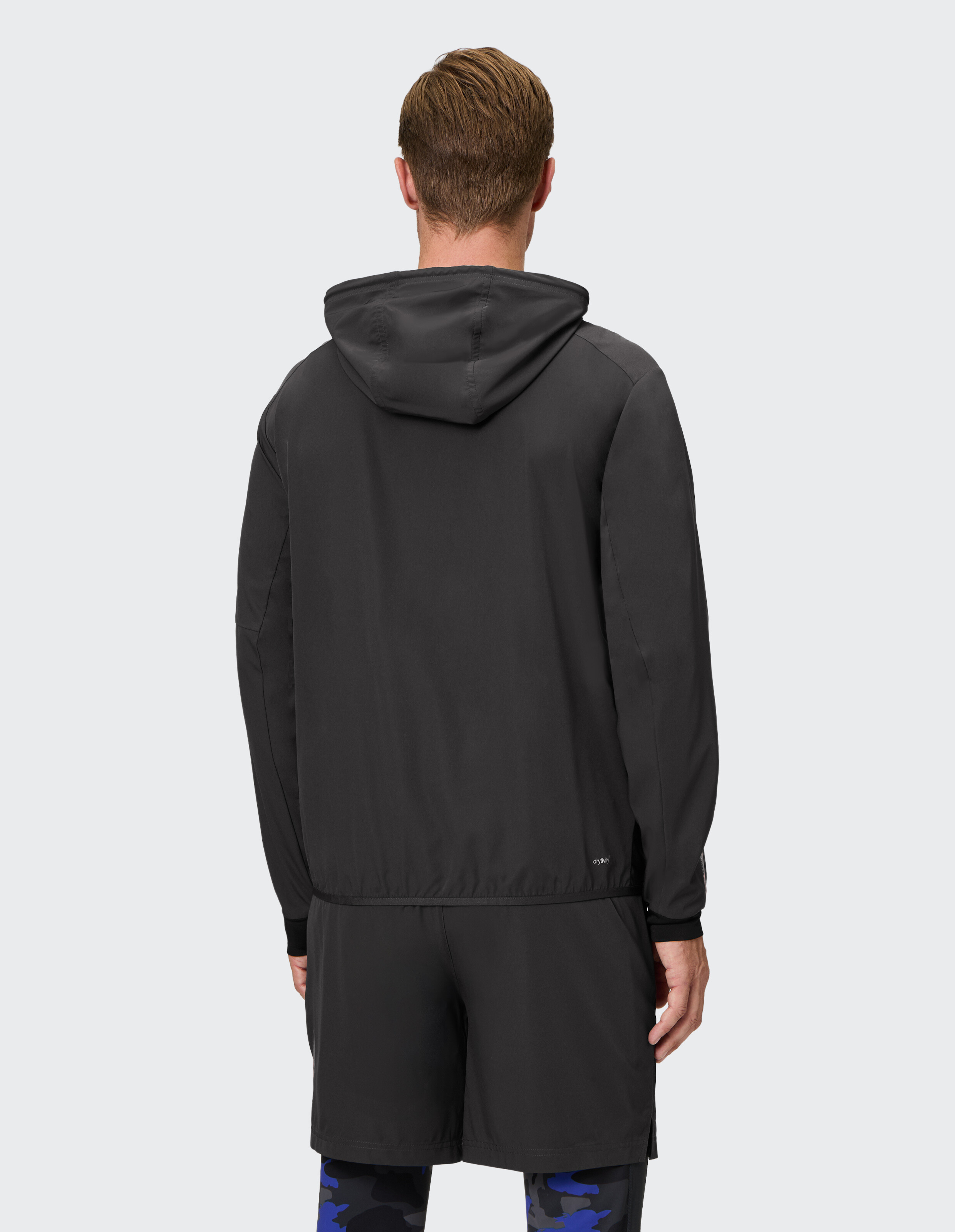 Rückansicht eines Mannes in einem schwarzen, leichten Kapuzenpullover und Shorts, ideal für Freizeitkleidung.