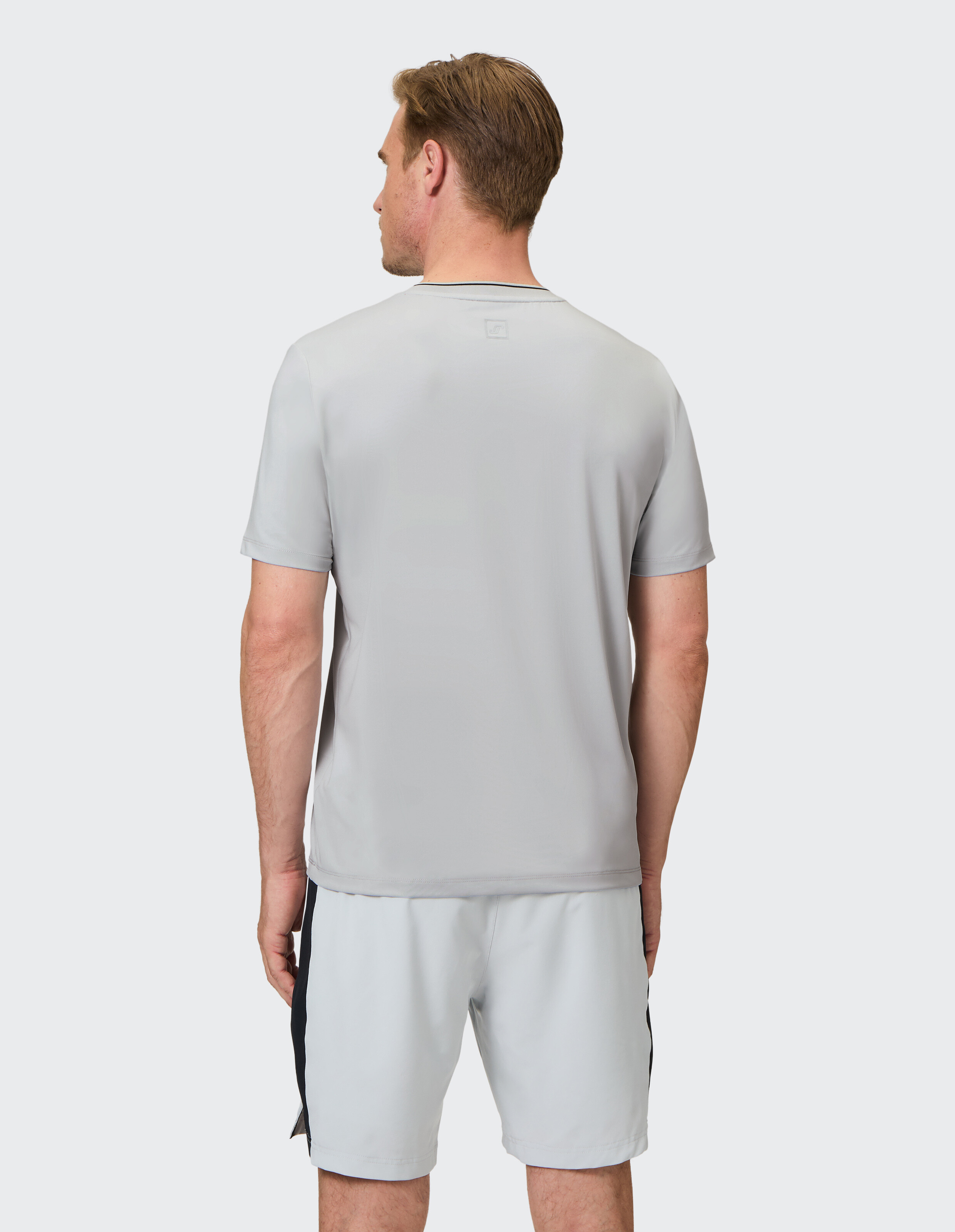Mann trägt ein hellgraues Freizeit-T-Shirt und passende Shorts für einen bequemen Lounge-Look.