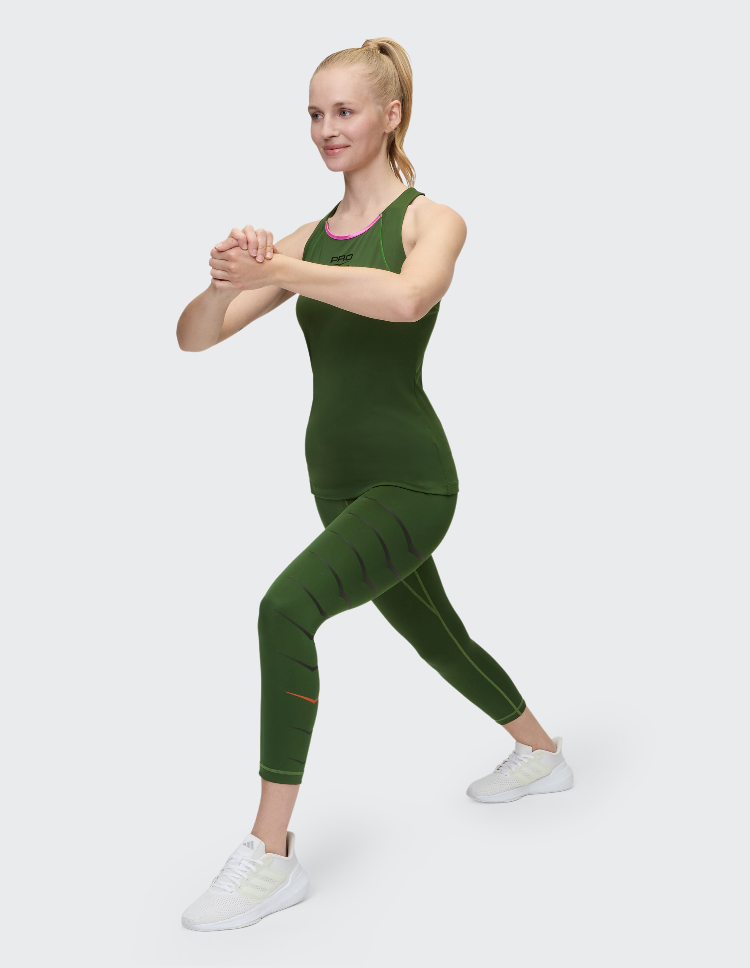 Frau trägt olivgrüne 7/8-Tights Lexington und passendes Tanktop für Fitness.