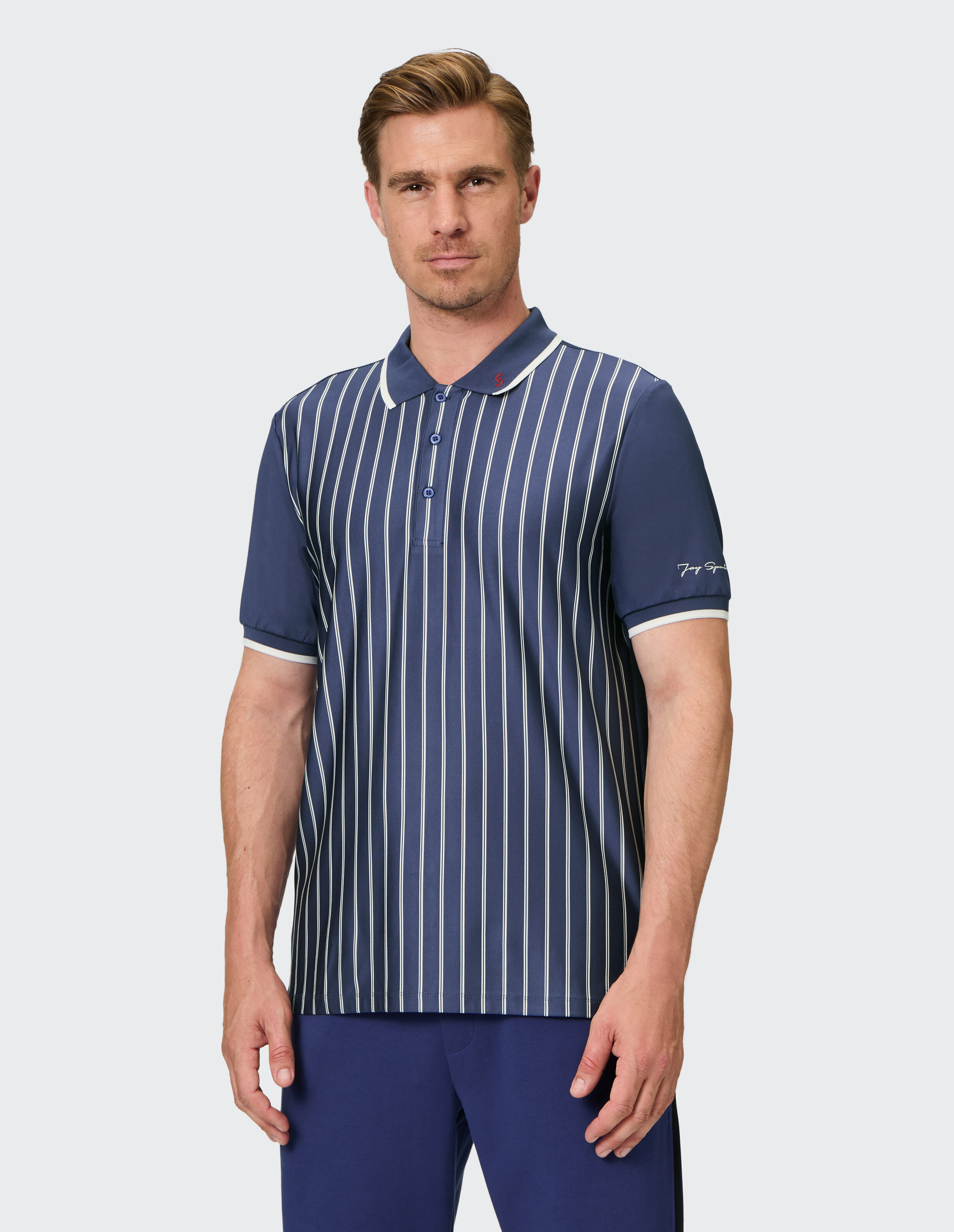 Mann trägt ein dunkelblau gestreiftes Poloshirt mit weißem Besatz für einen klassischen, lässigen Look.