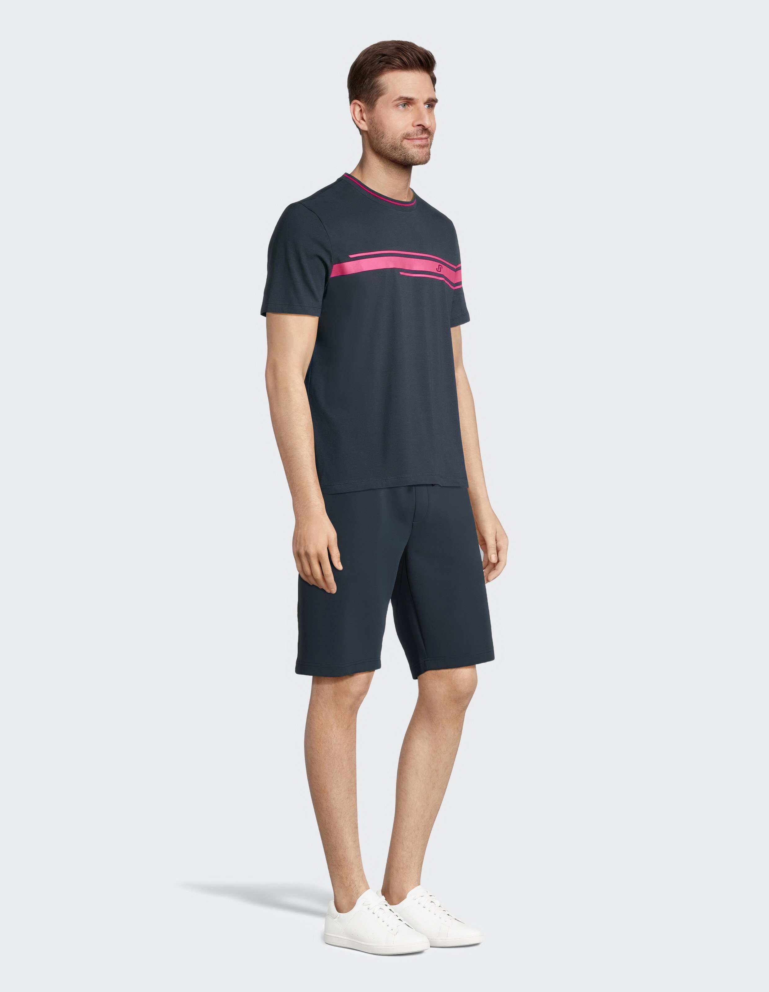 Mann im marineblauen Freizeitoutfit mit rosa Streifen, perfekt zum Faulenzen oder für Freizeitausflüge.
