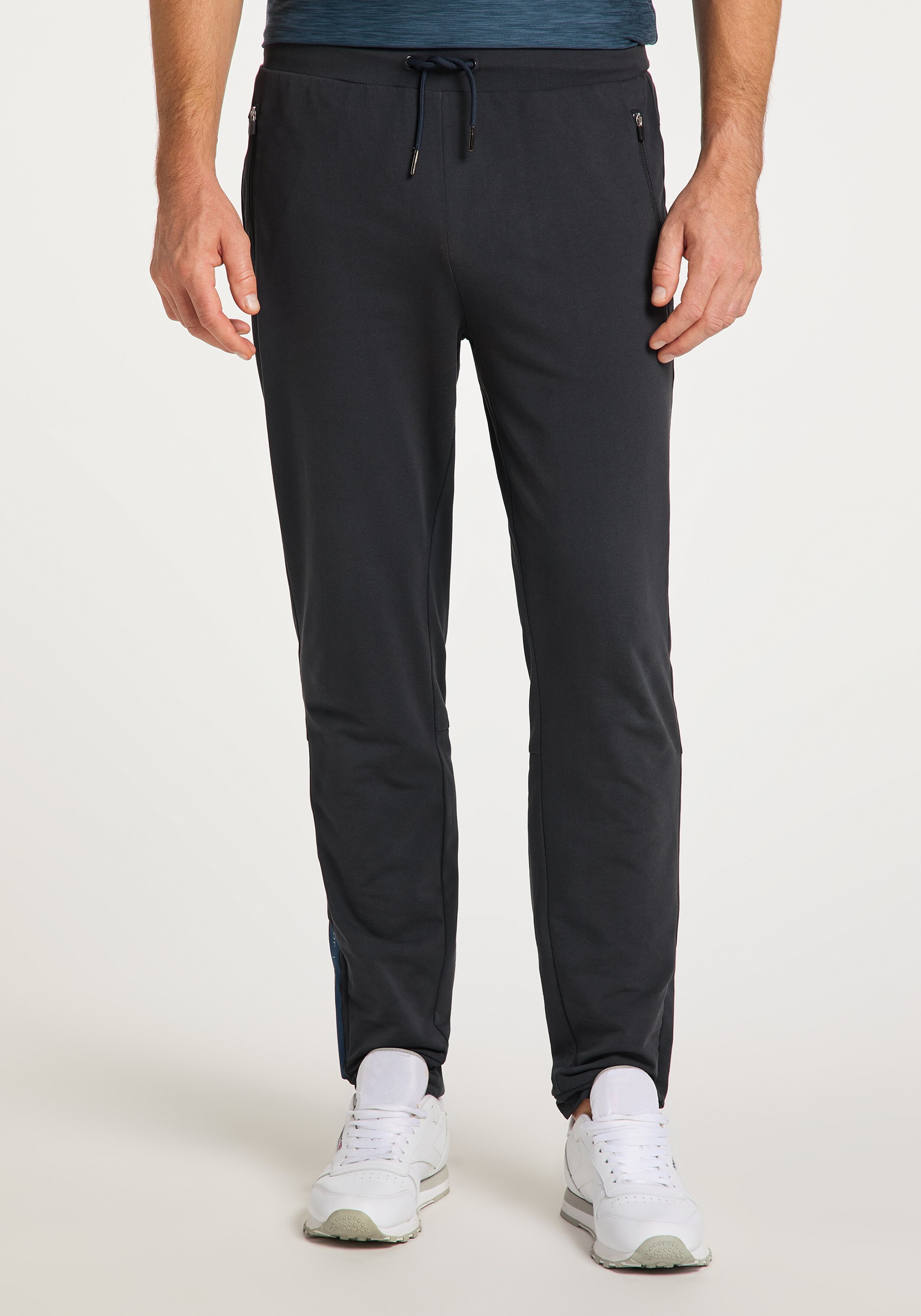 Dunkelblaue Jogginghose mit Kordelzug und elastischen Bündchen, zwei Seitentaschen mit Reißverschluss, aus weichem Stoff.