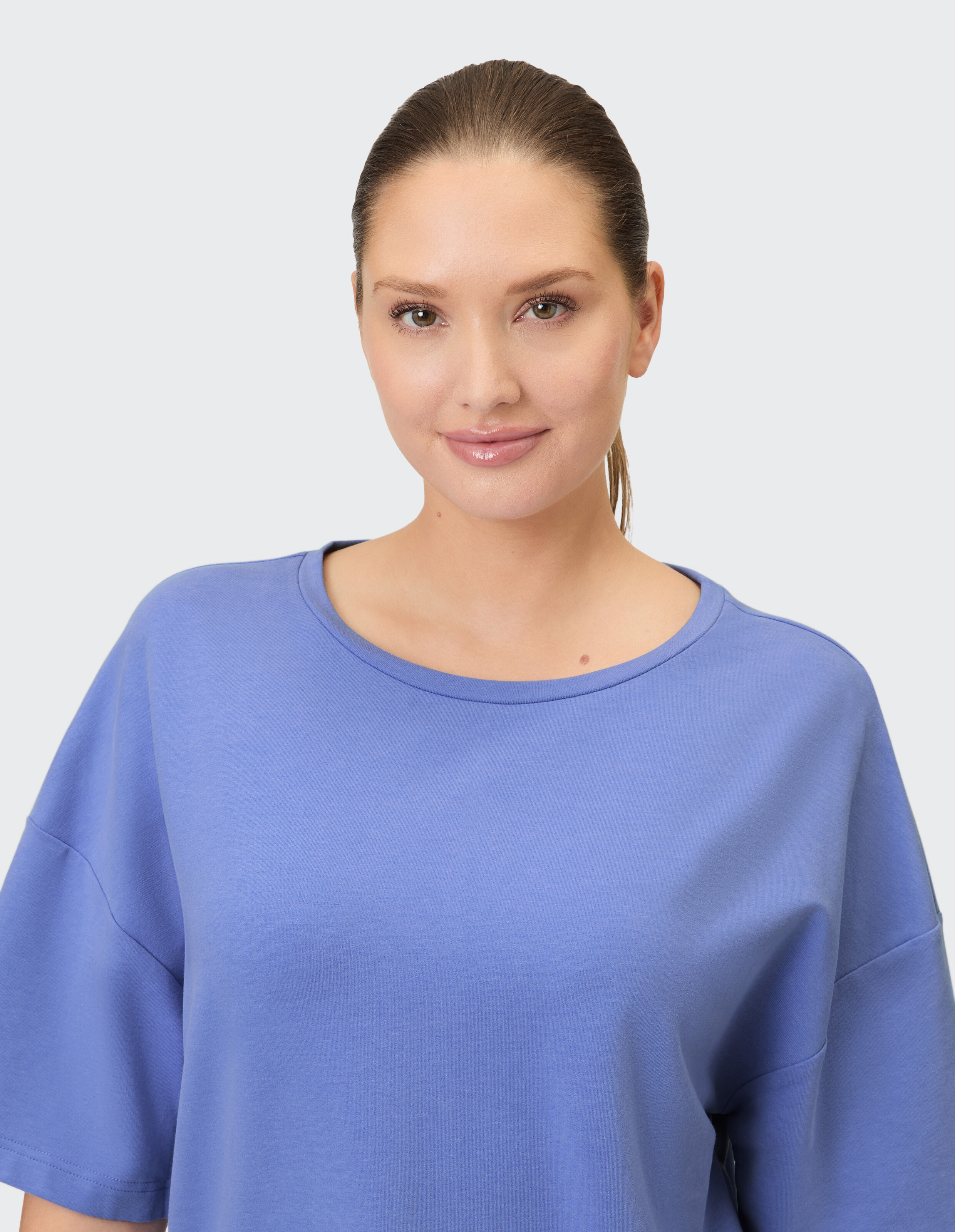 Das Model trägt ein gemütliches blaues, übergroßes T-Shirt, perfekt für Freizeitkleidung.
