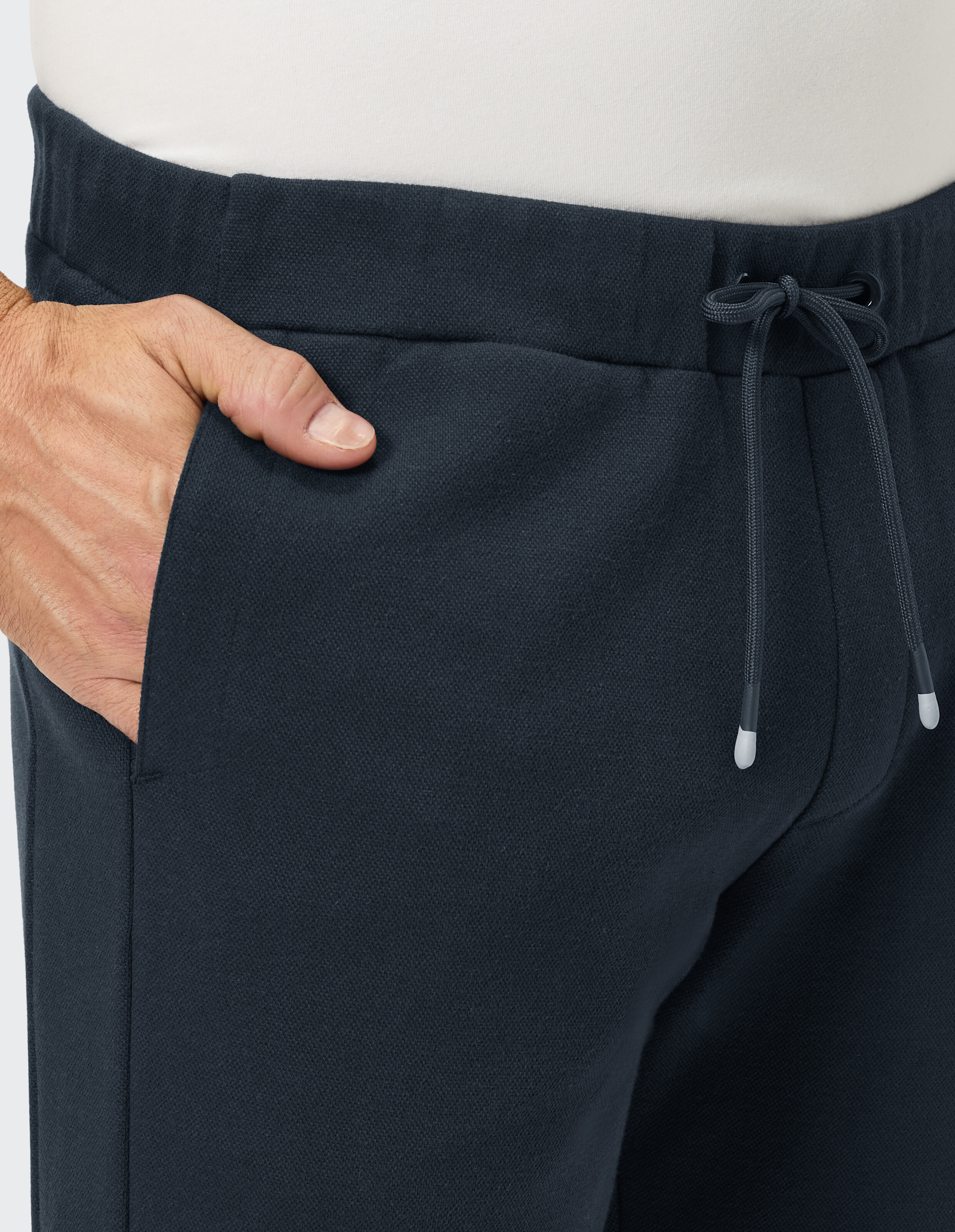 Nahaufnahme einer marineblauen Freizeithose mit Kordelzug und Seitentaschendetail.