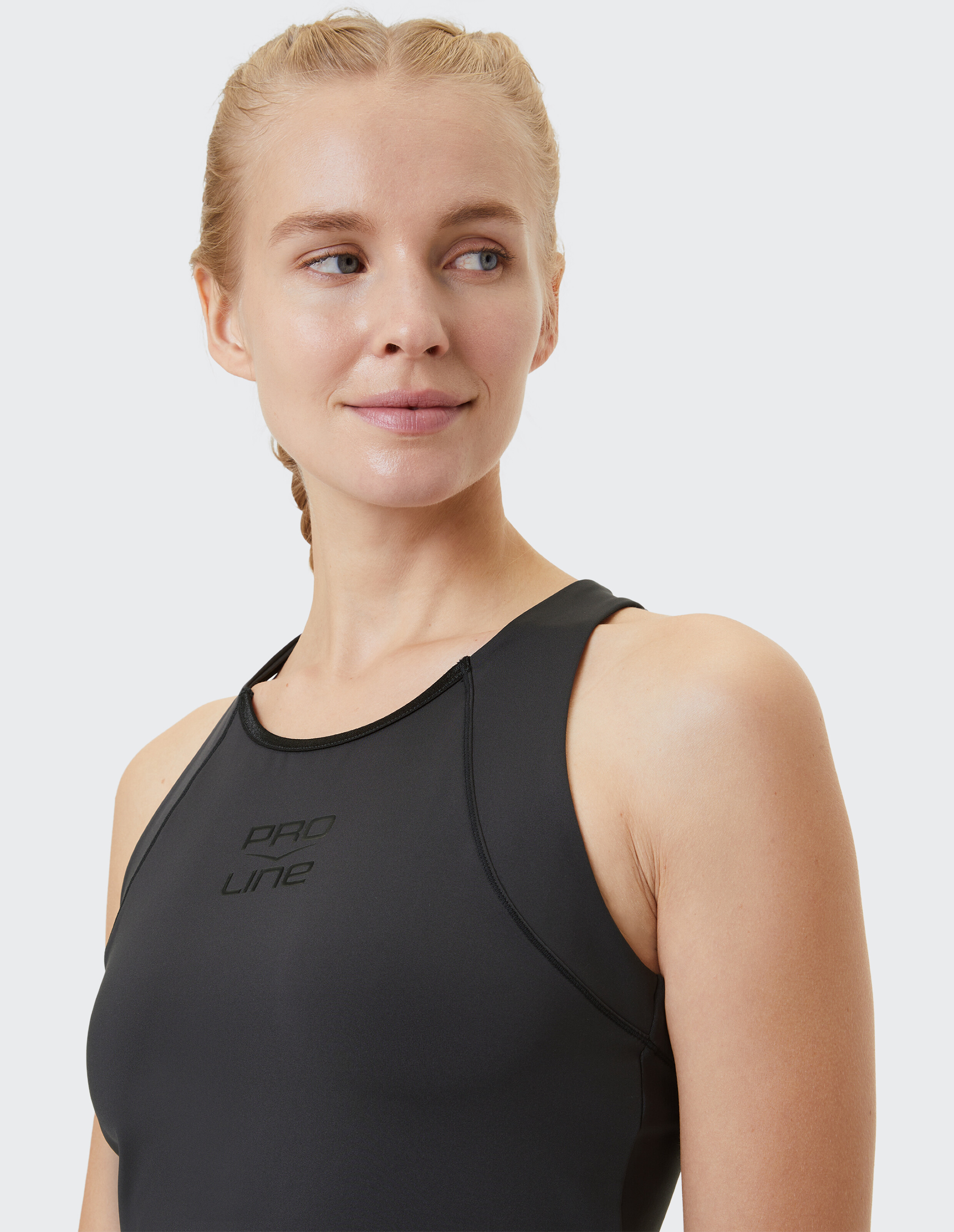 Nahaufnahme einer Frau in einem schwarzen ärmellosen Top, die einen sportlichen und lässigen Stil zeigt.