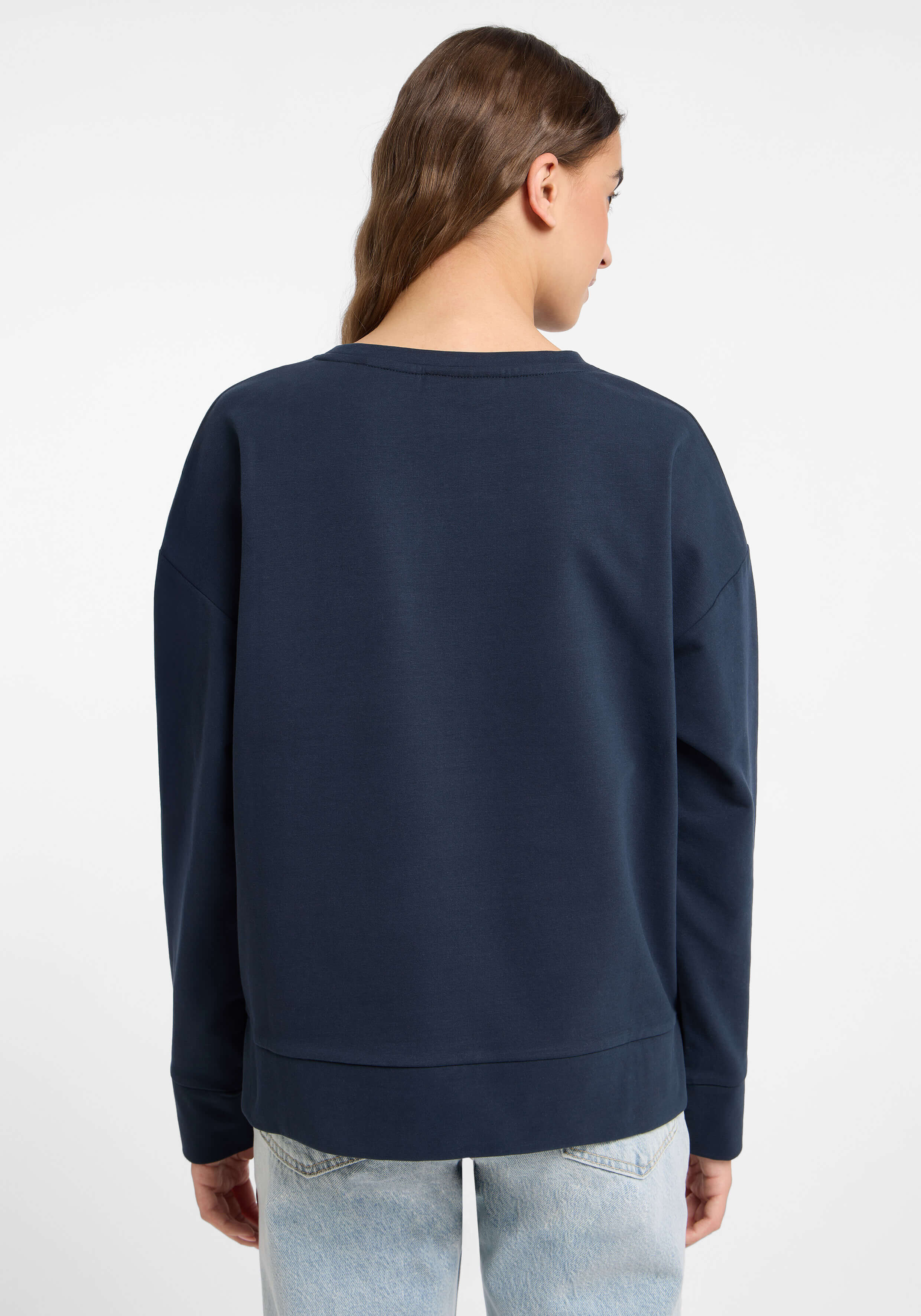 Rückansicht einer Frau in einem dunkelblauen, übergroßen Sweatshirt mit langen Ärmeln.