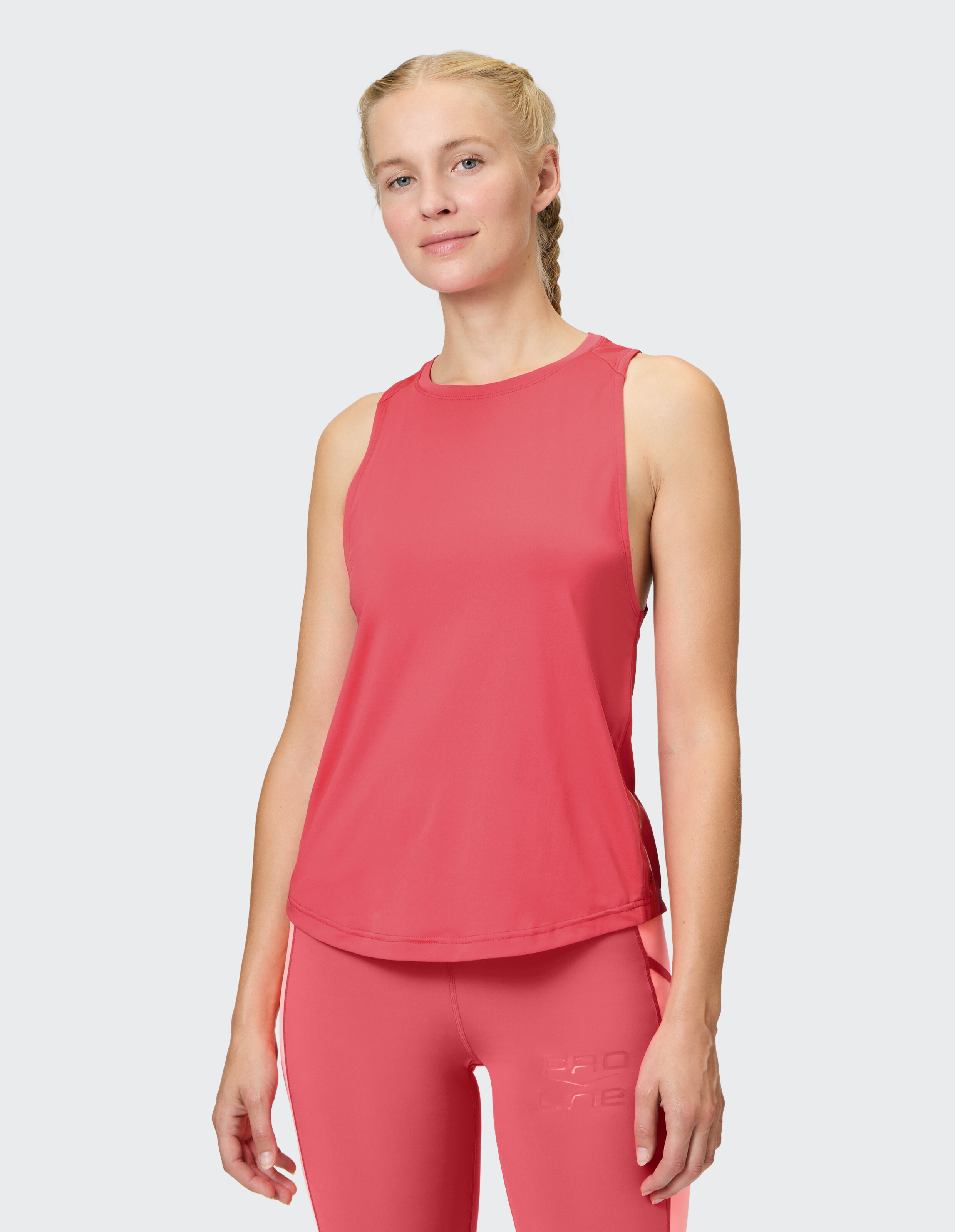 Frau trägt ein rosa ärmelloses Top und passende Leggings, ideal für Freizeitkleidung.
