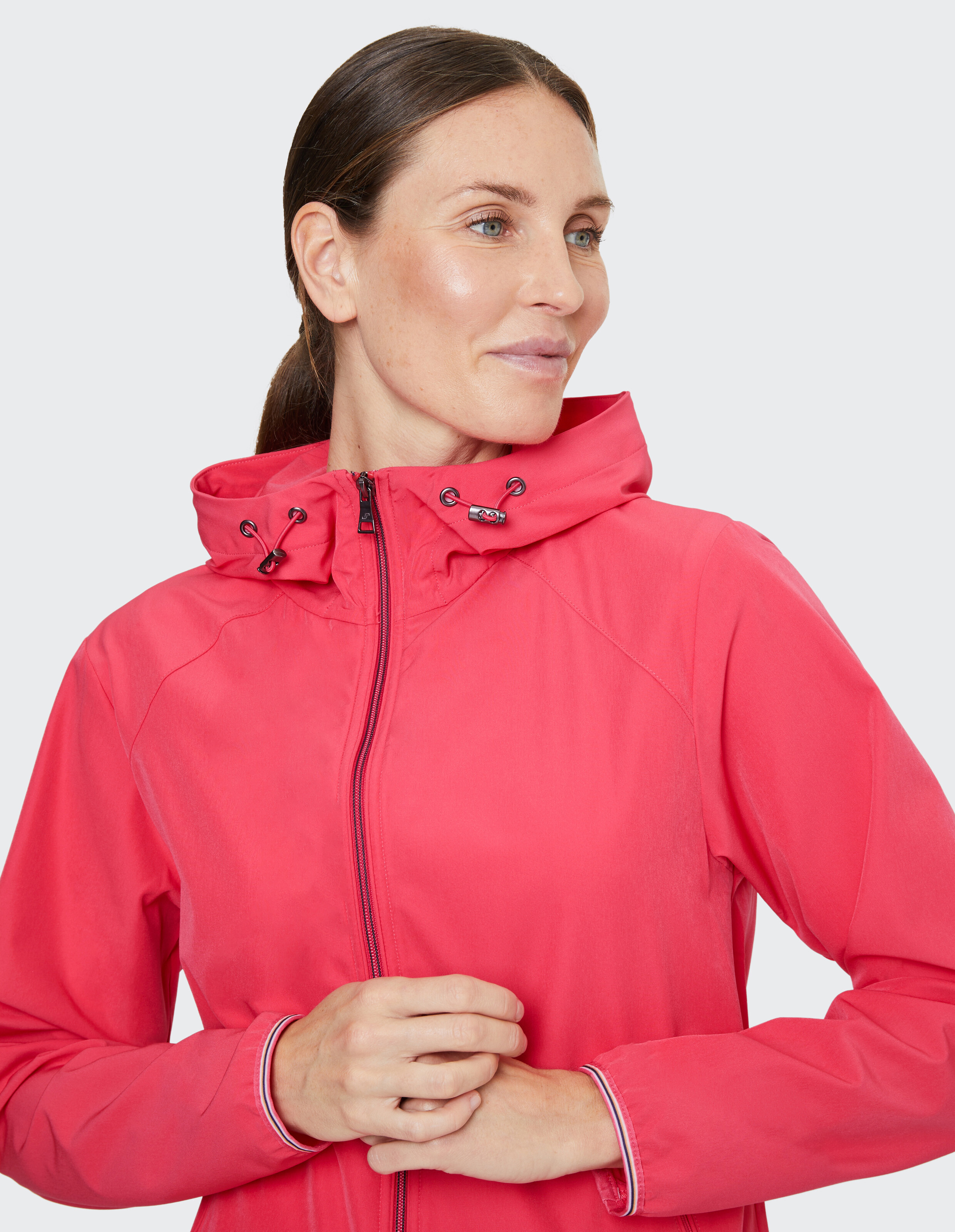 Frau trägt eine leuchtend rosa lässige Kapuzenjacke für Outdoor-Freizeitkleidung.
