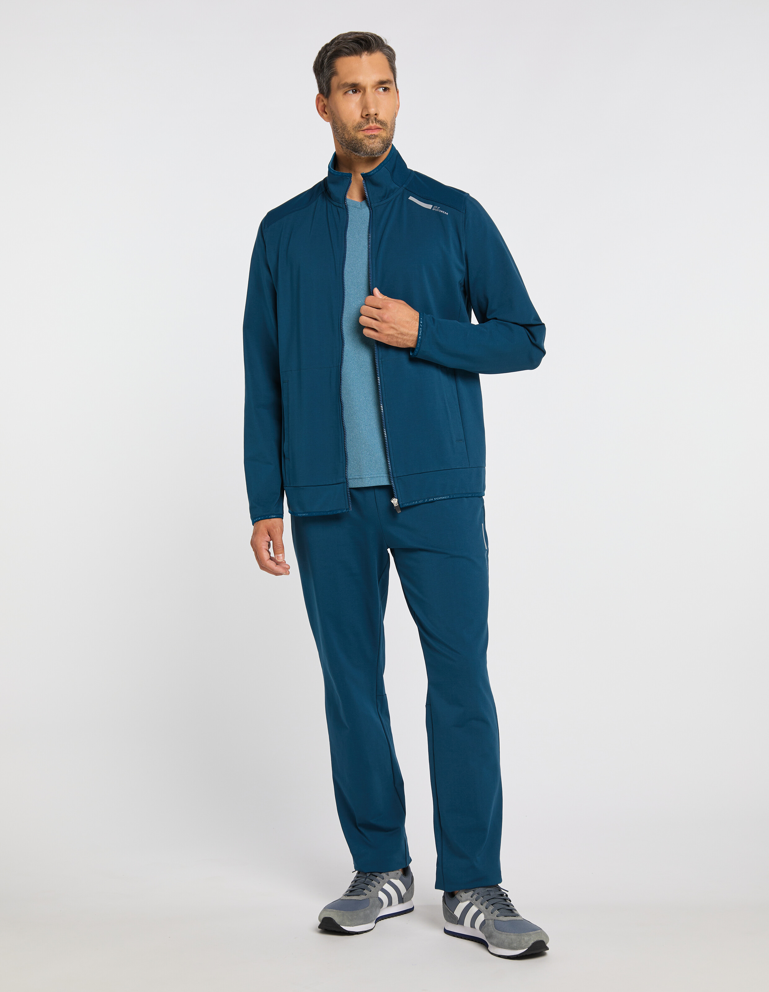 Blaue Jacke mit durchgehendem Reißverschluss, hohem Kragen und zwei seitlichen Taschen, ideal für sportliche Aktivitäten.