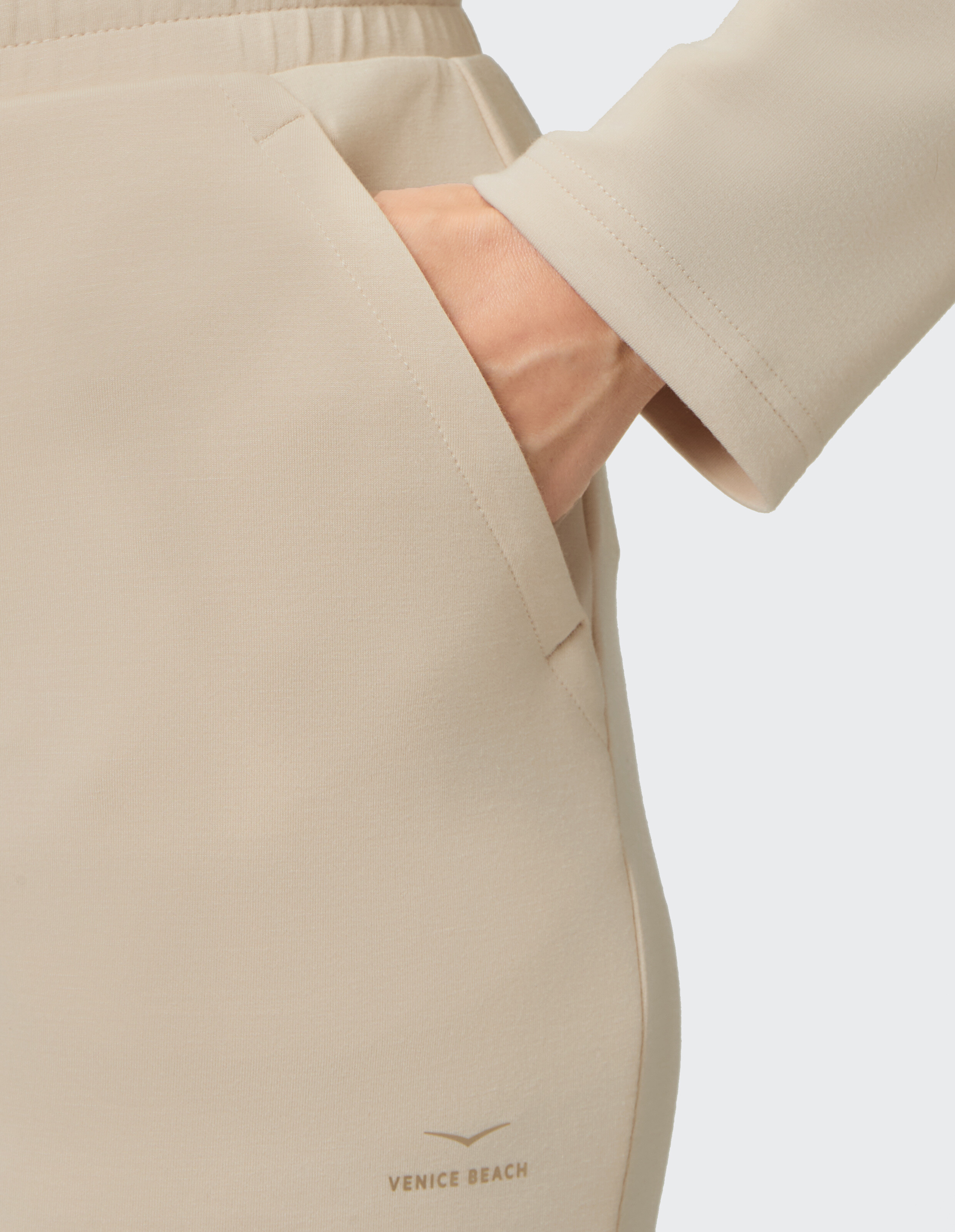 Nahaufnahme einer beige Freizeittasche mit einer Hand aus weichem Stoff.