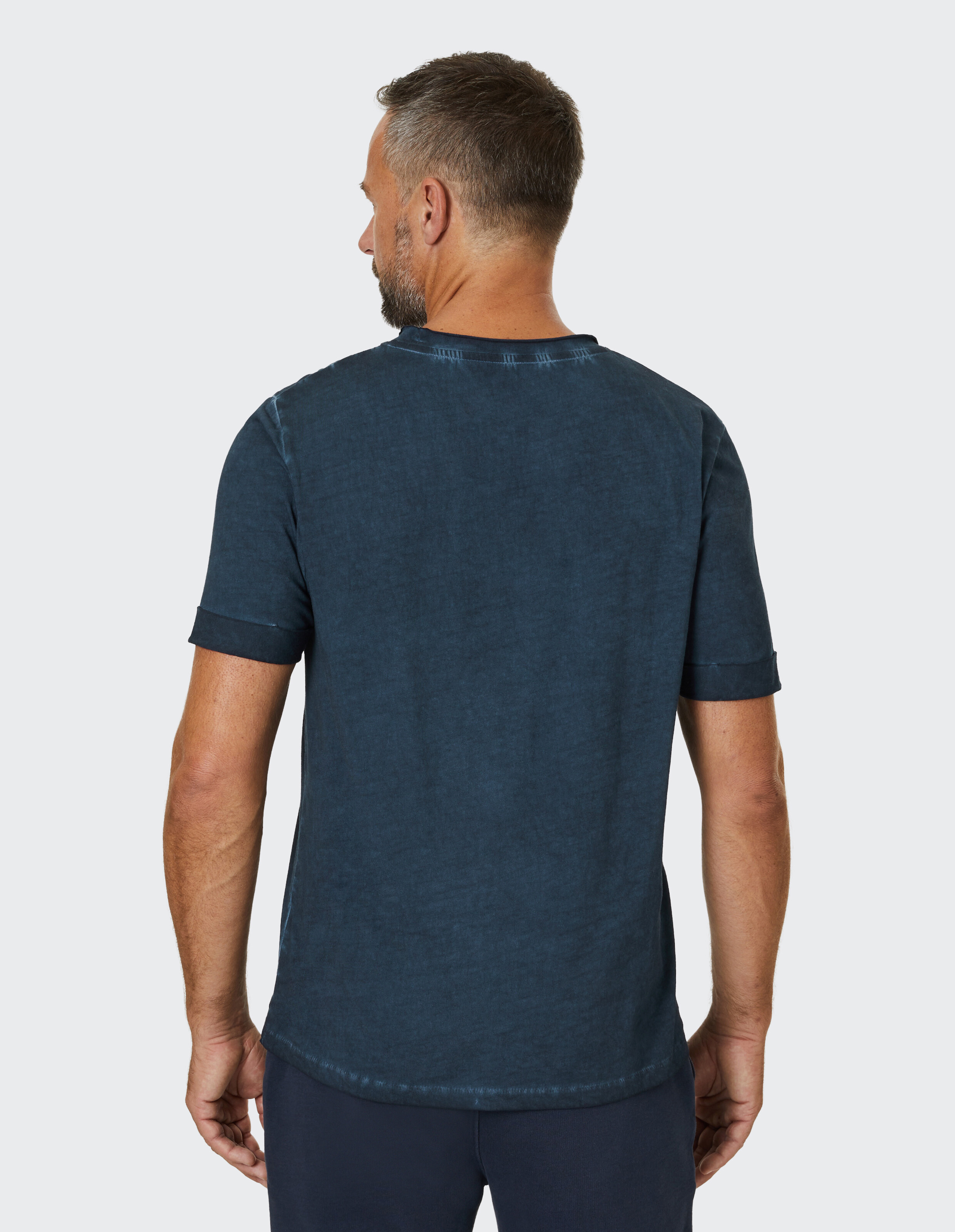 Mann trägt ein dunkelblaues Freizeit-T-Shirt mit Vintage-Waschung, Rückansicht.