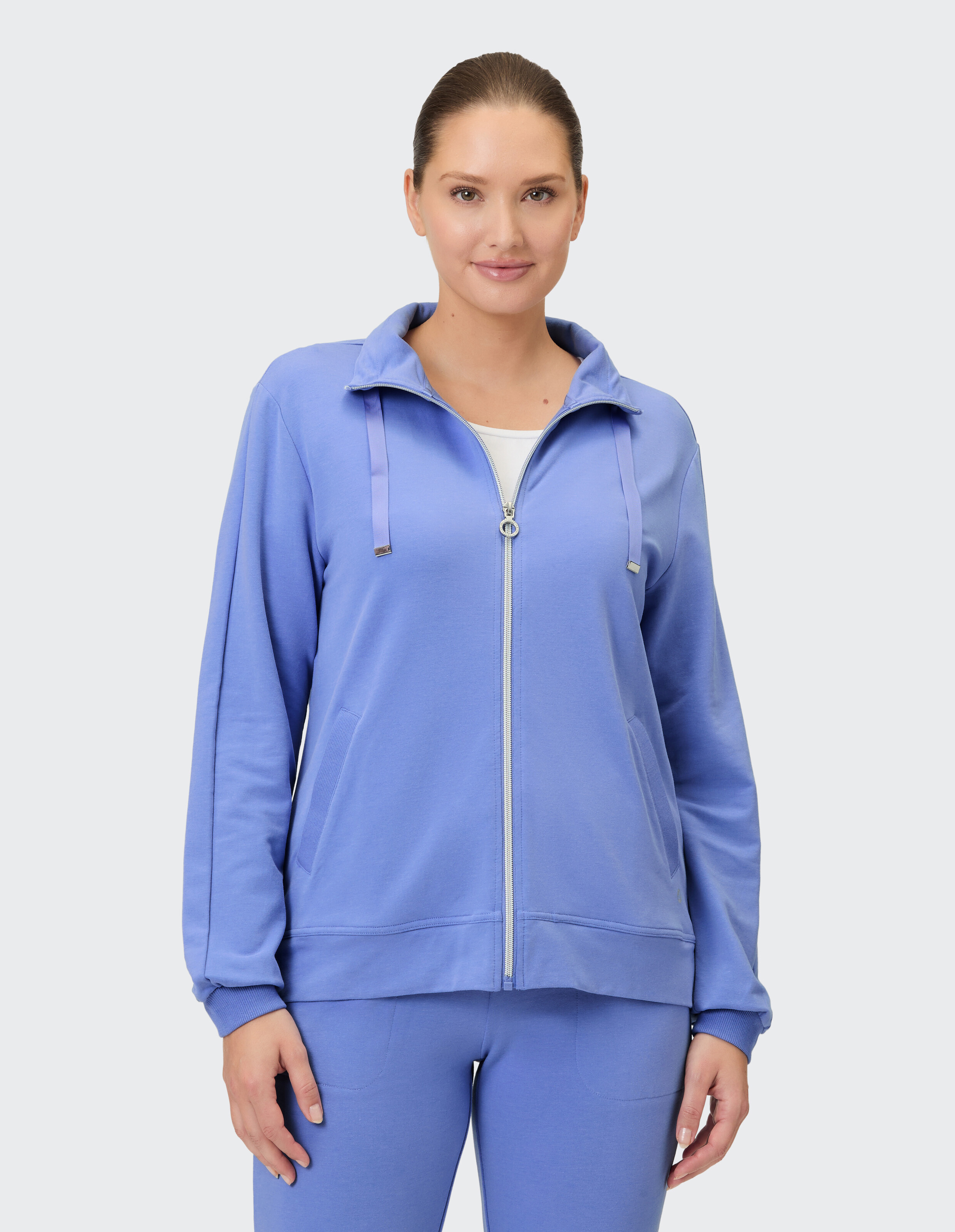 Frau in einem hellblauen Kapuzenpullover mit Reißverschluss, perfekt für Freizeitkleidung und Faulenzen.