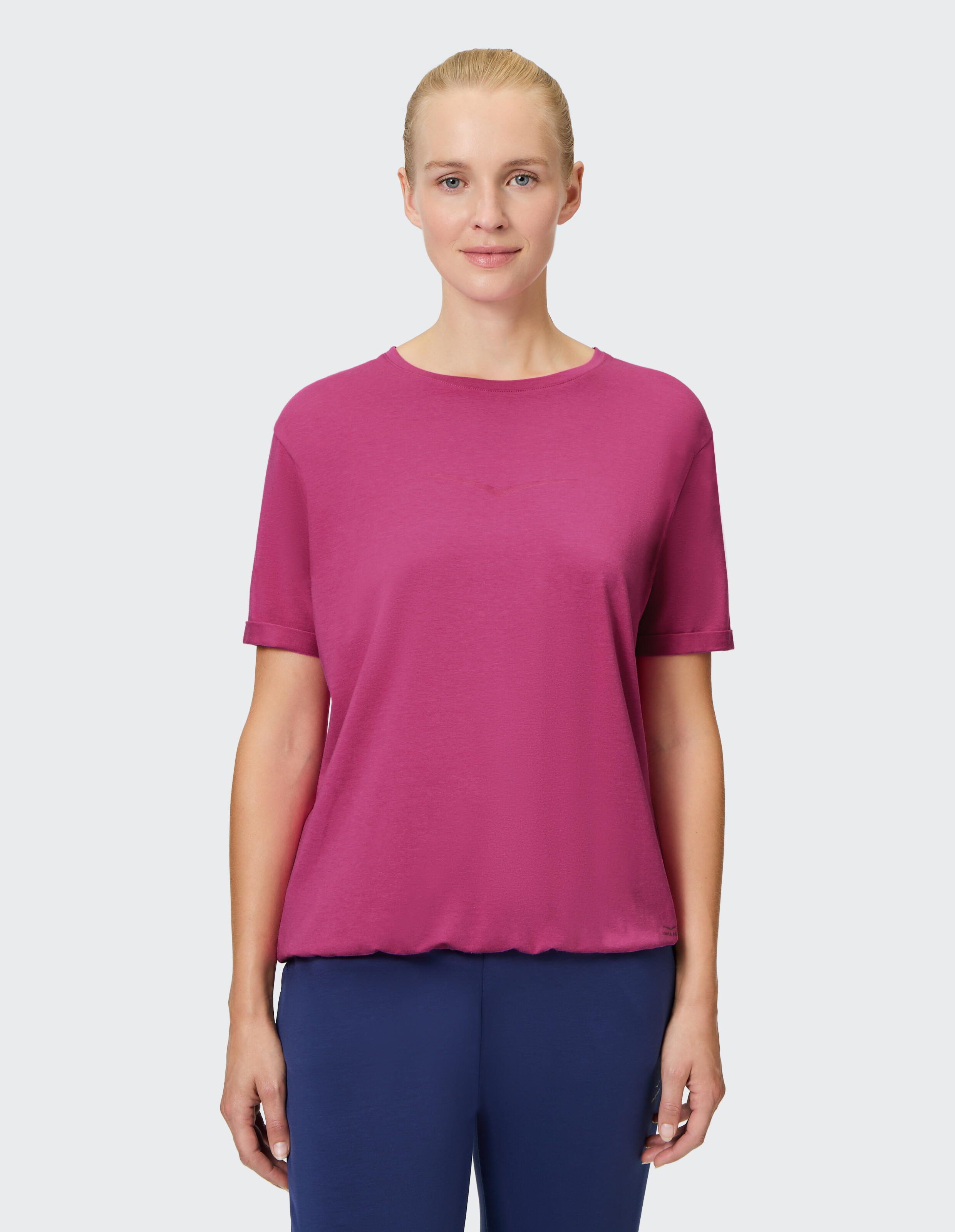 Frau trägt ein gemütliches, rosafarbenes, kurzärmliges Freizeit-T-Shirt zum Entspannen.
