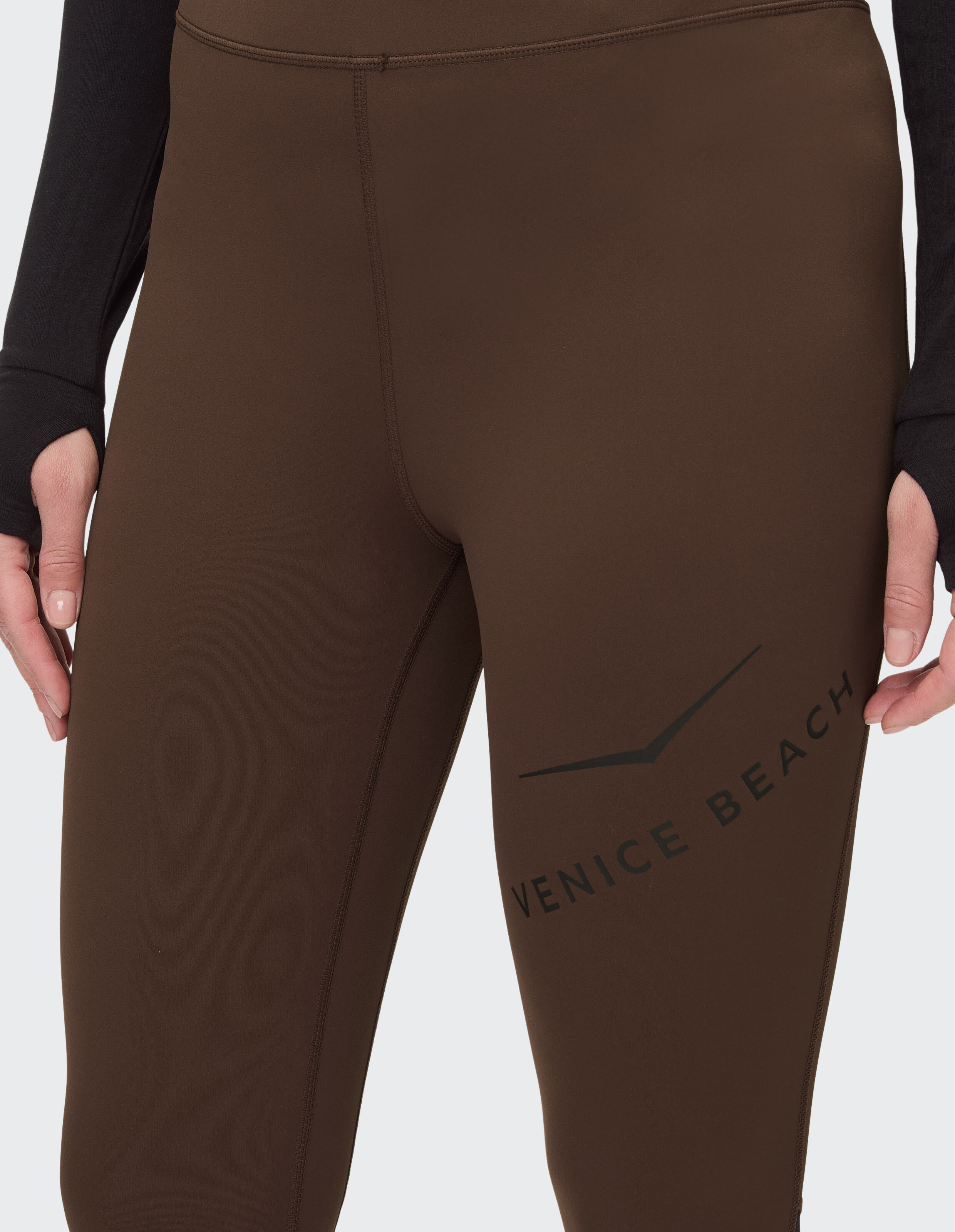 Nahaufnahme einer braunen Leggings mit hoher Taille und Venice Beach-Logo für Freizeitkleidung.