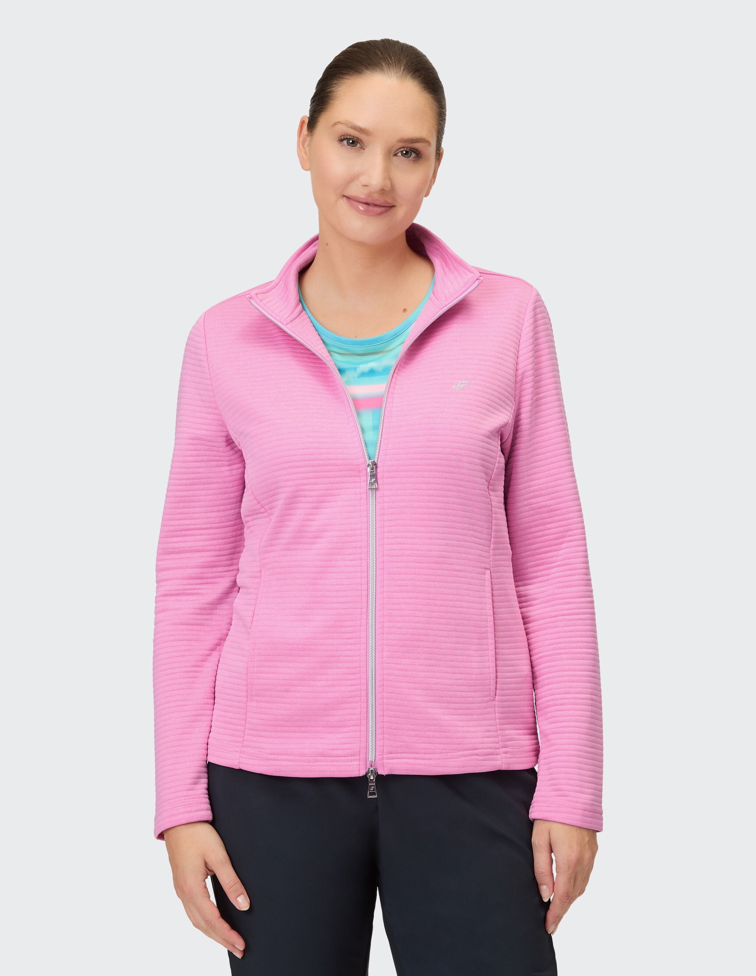 Frau trägt eine kuschelige rosa Jacke mit Reißverschluss, perfekt für Freizeitausflüge.