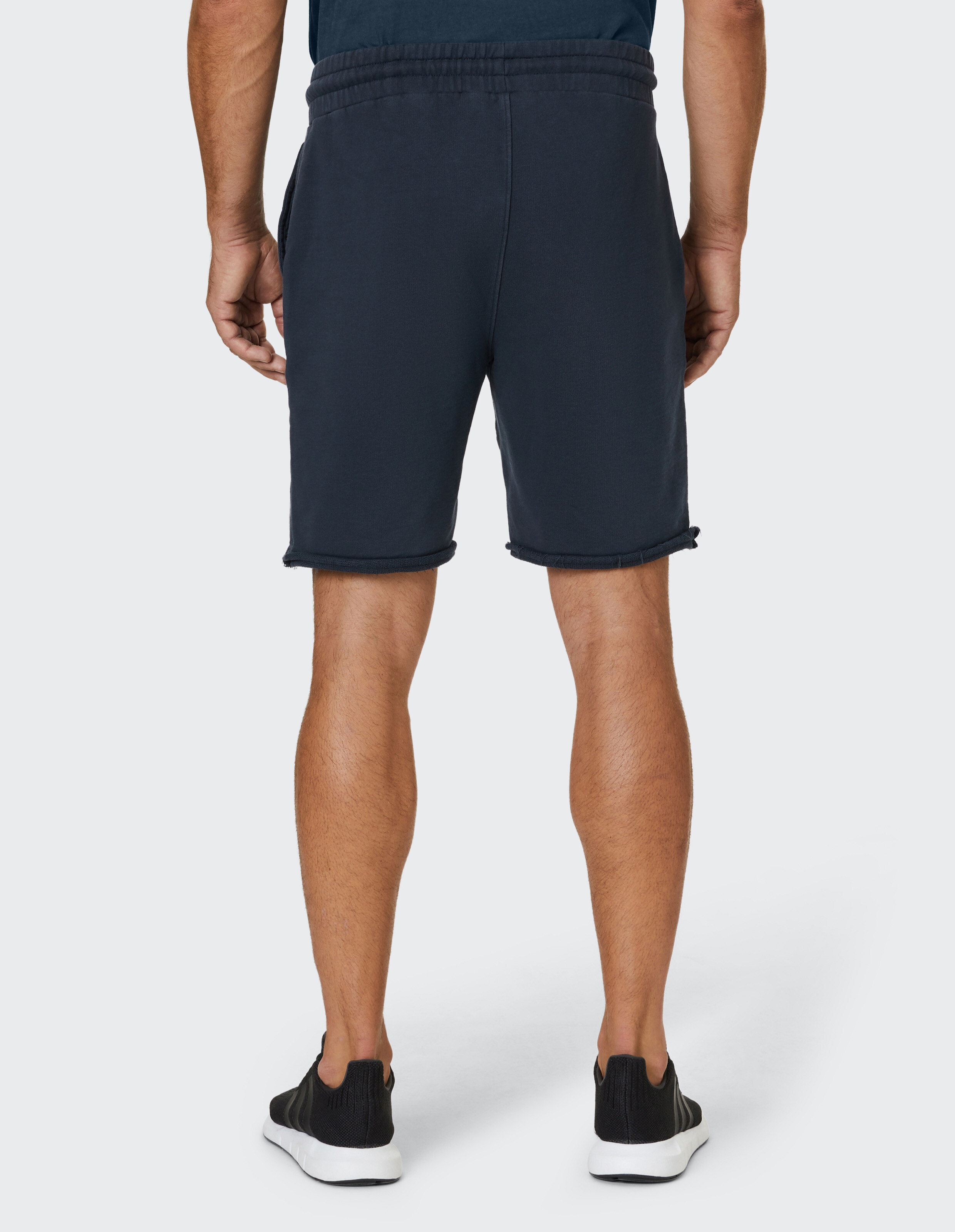 Dunkelblaues Sweatshorts aus weichem Stoff mit elastischem Bund, Kordelzug und leicht fransigen Beinabschlüssen.