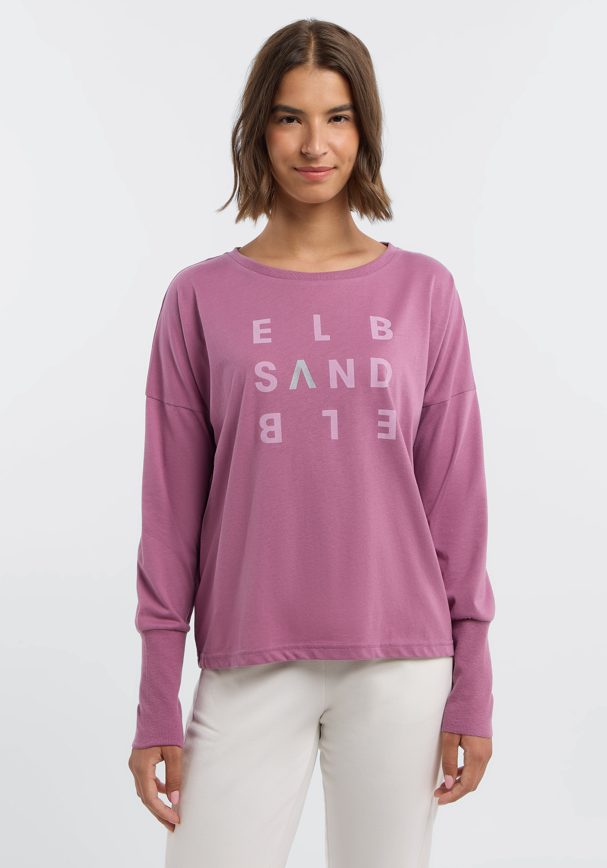 Frau trägt ein gemütliches lila ELBSAND-Langarmshirt mit Logo-Print.
