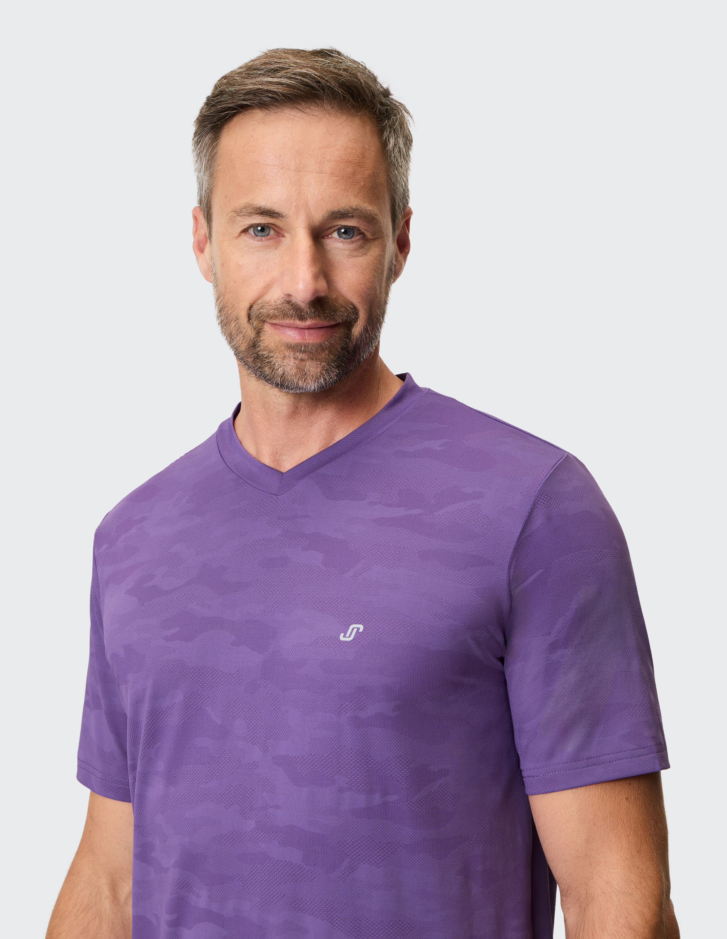 Mann trägt ein lila T-Shirt mit V-Ausschnitt und dezentem Tarnmuster für lässigen Stil.