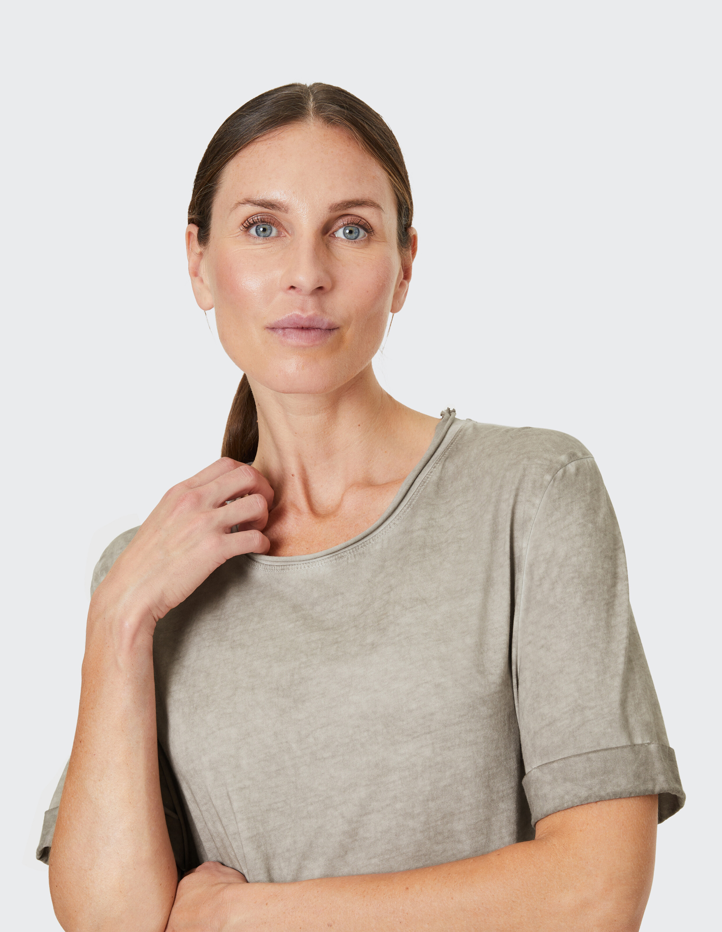 Frau trägt ein gemütliches, lässiges salbeigrünes T-Shirt mit entspannter Passform.