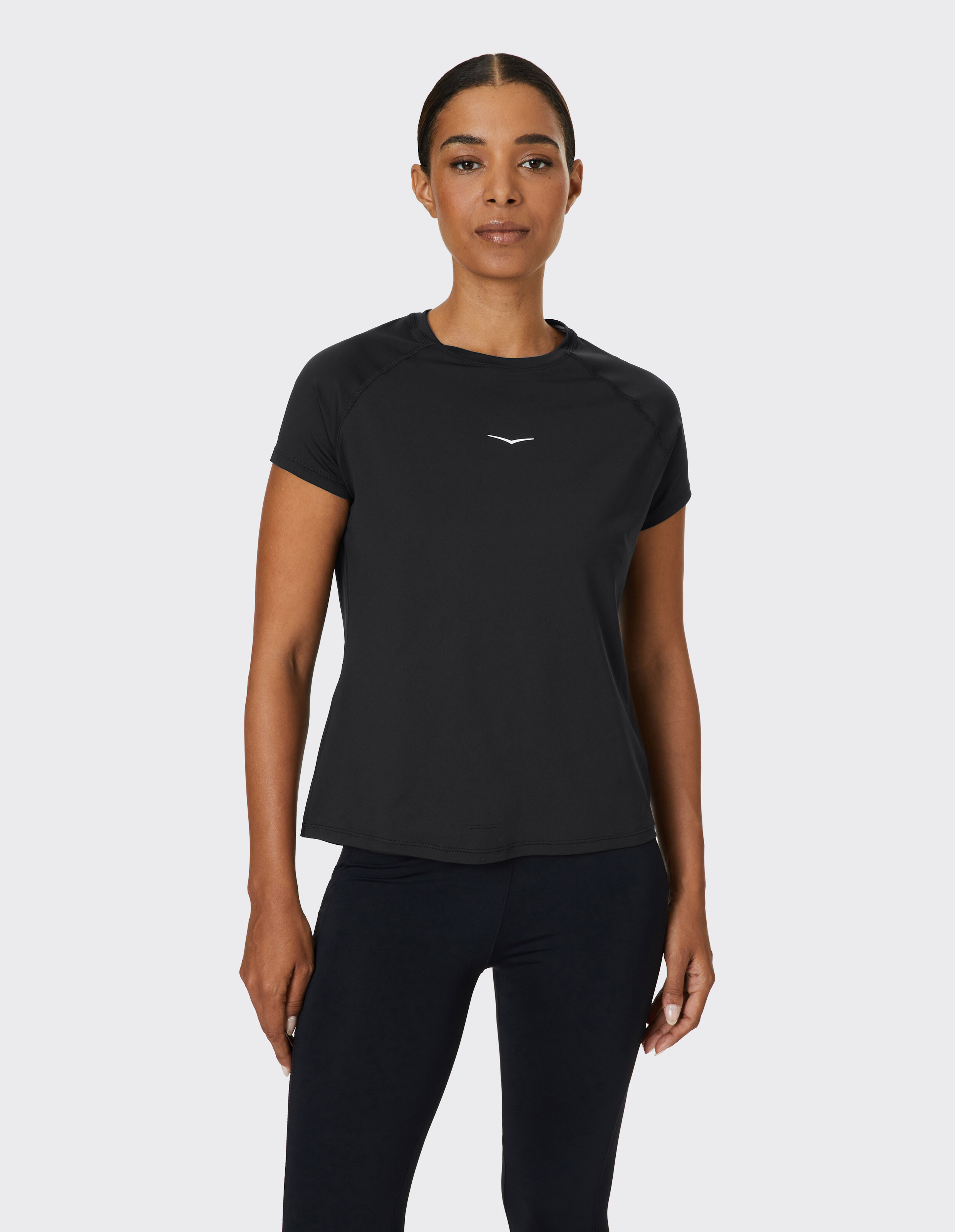 Frau trägt ein schwarzes, kurzärmeliges Freizeit-T-Shirt mit kleinem Logo.
