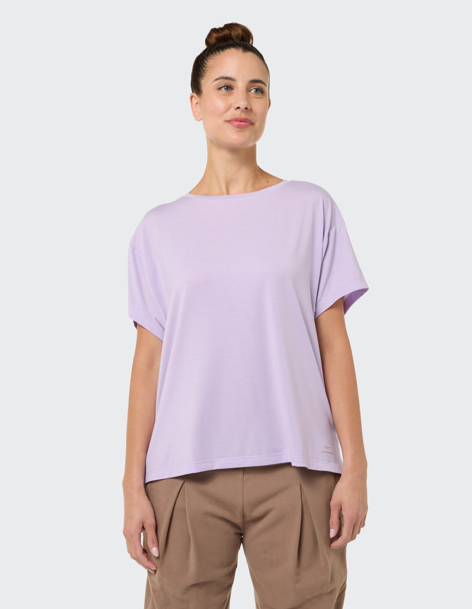 Hellviolettes, übergroßes T-Shirt gepaart mit einer beigen Hose, perfekt für Freizeitkleidung.