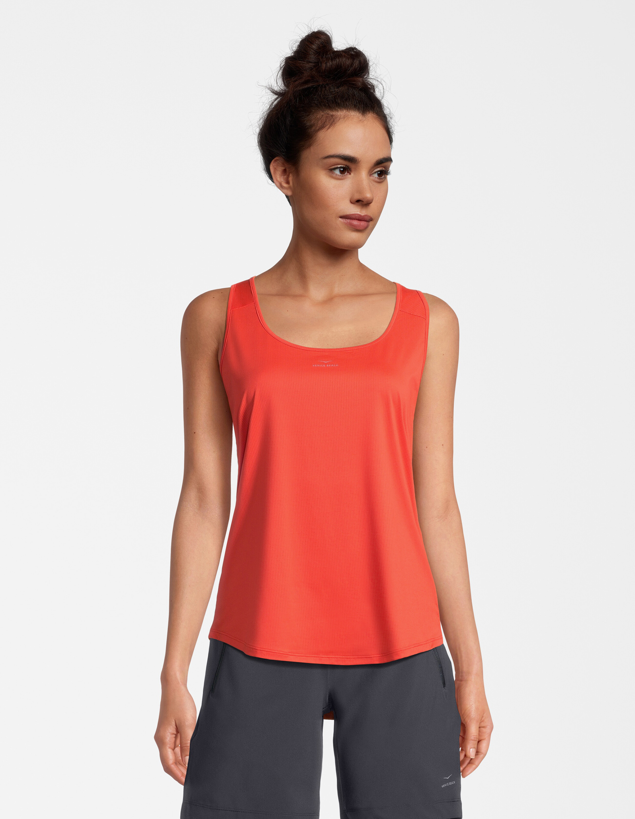 Das Model trägt ein leuchtend rotes Tanktop, perfekt für Freizeitausflüge oder Workouts.