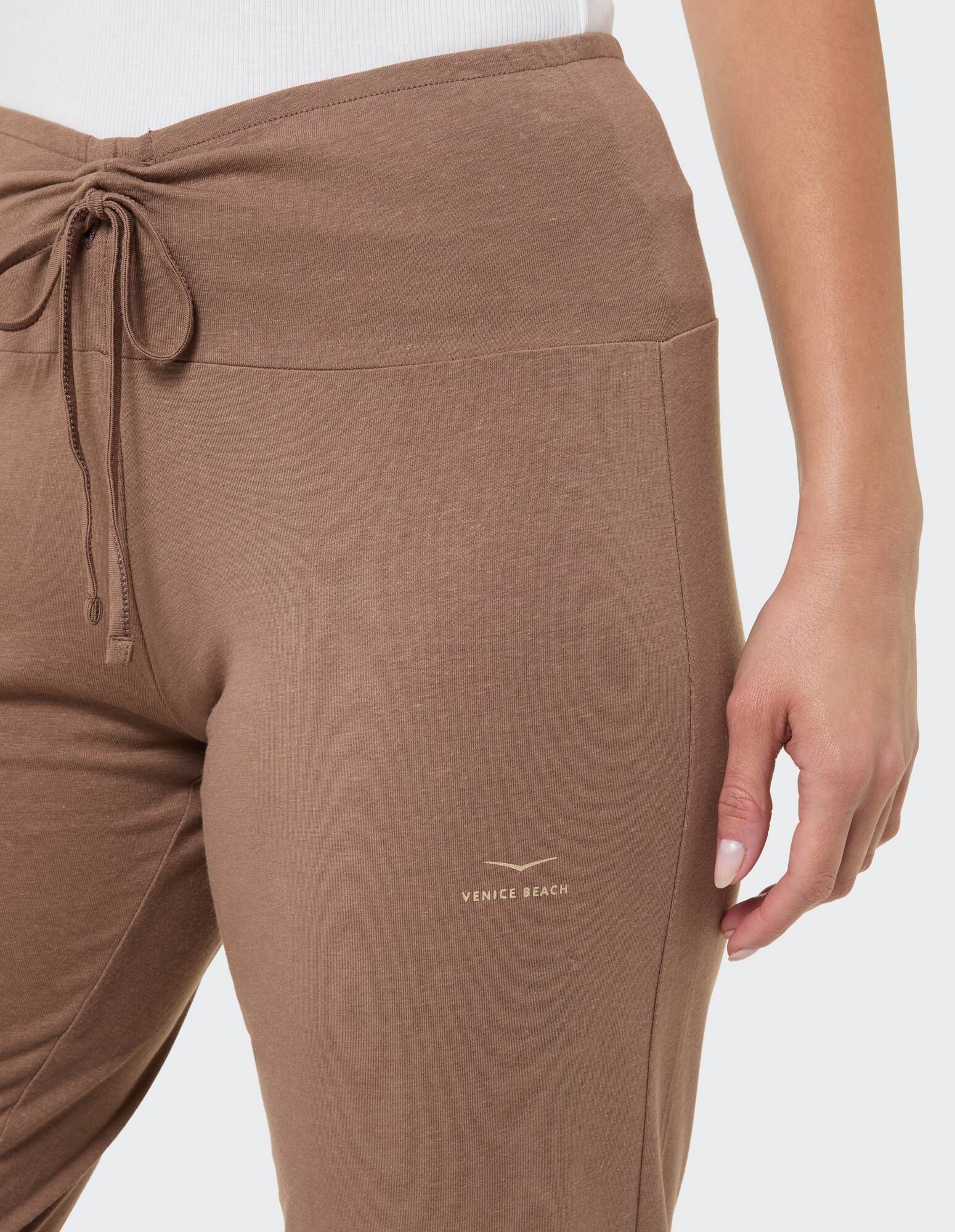 Nahaufnahme einer braunen Freizeithose mit Kordelzug und Venice Beach-Logo.
