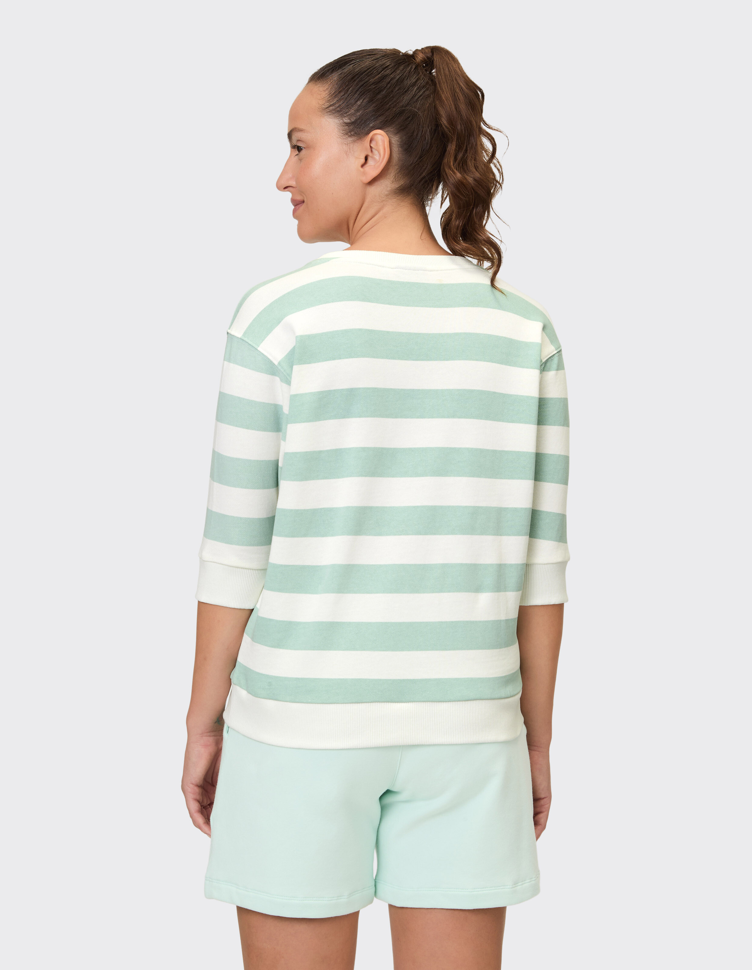 Frau trägt ein gemütliches, gestreiftes Venice Beach Janette-Sweatshirt zum entspannten Entspannen.