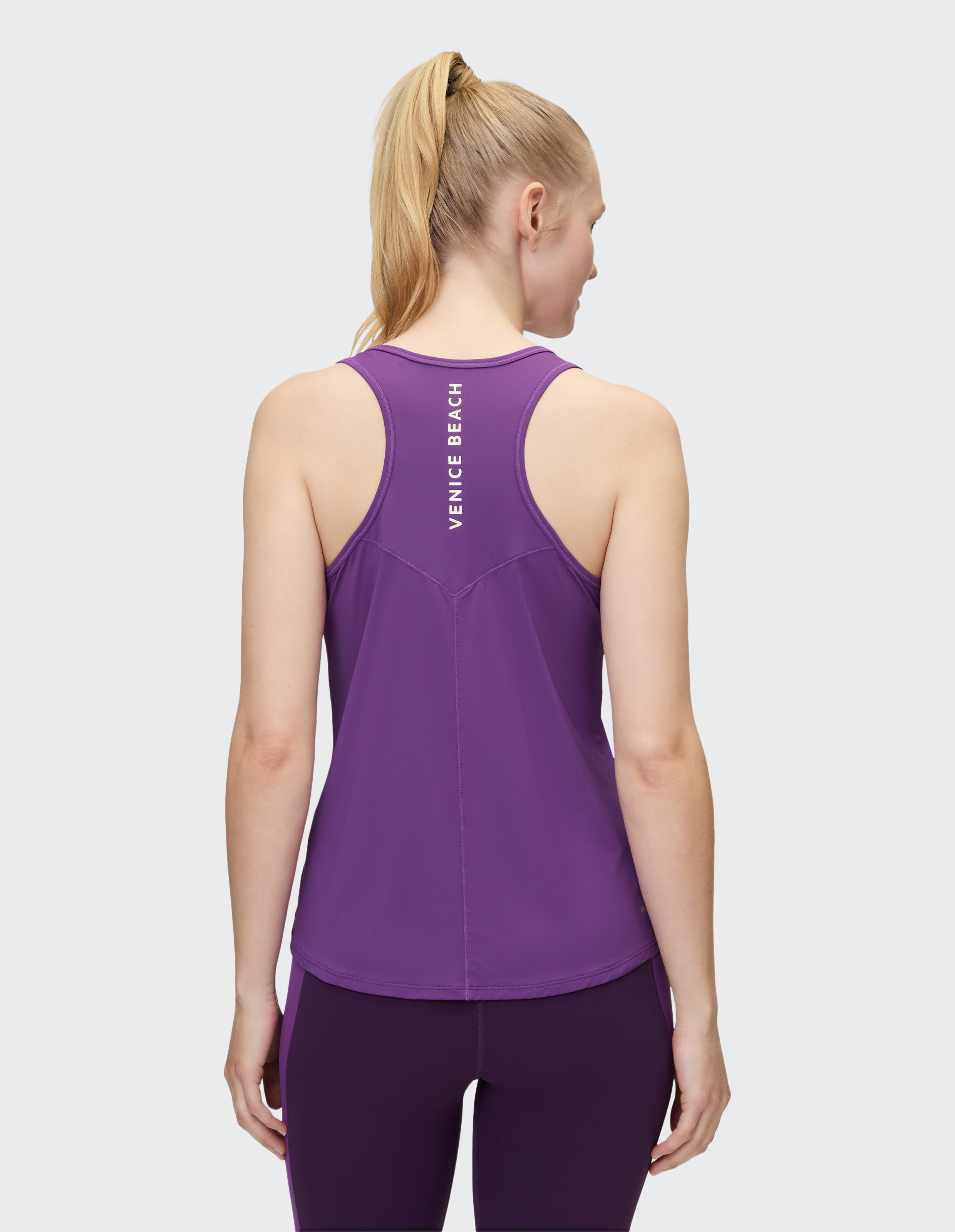 Rückansicht einer Frau in einem lila Tanktop, ideal für Freizeitkleidung und einen aktiven Lebensstil.