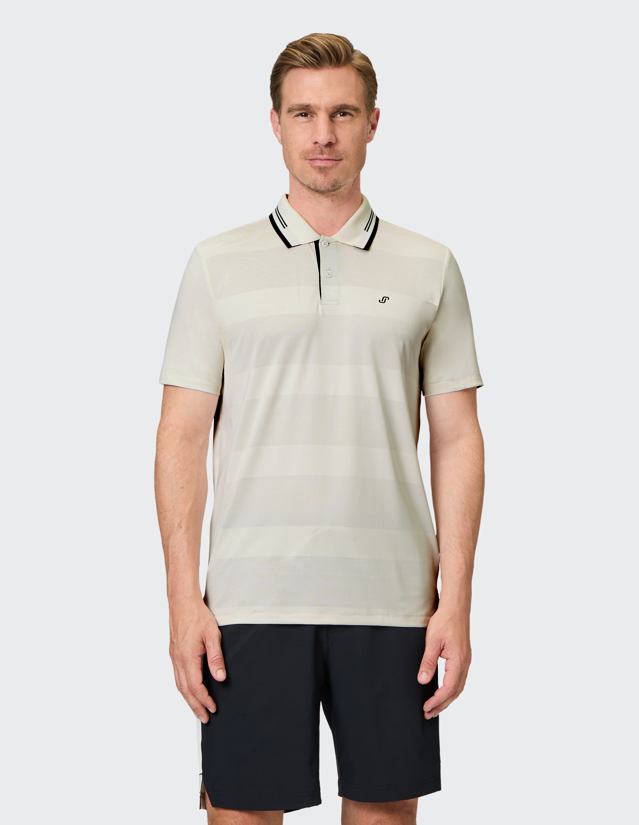 Beiges Polohemd mit schwarzen Details am Kragen und Knopfleiste, kurze Ärmel, dezentes Logo auf der Brust, sportlich-elegant.