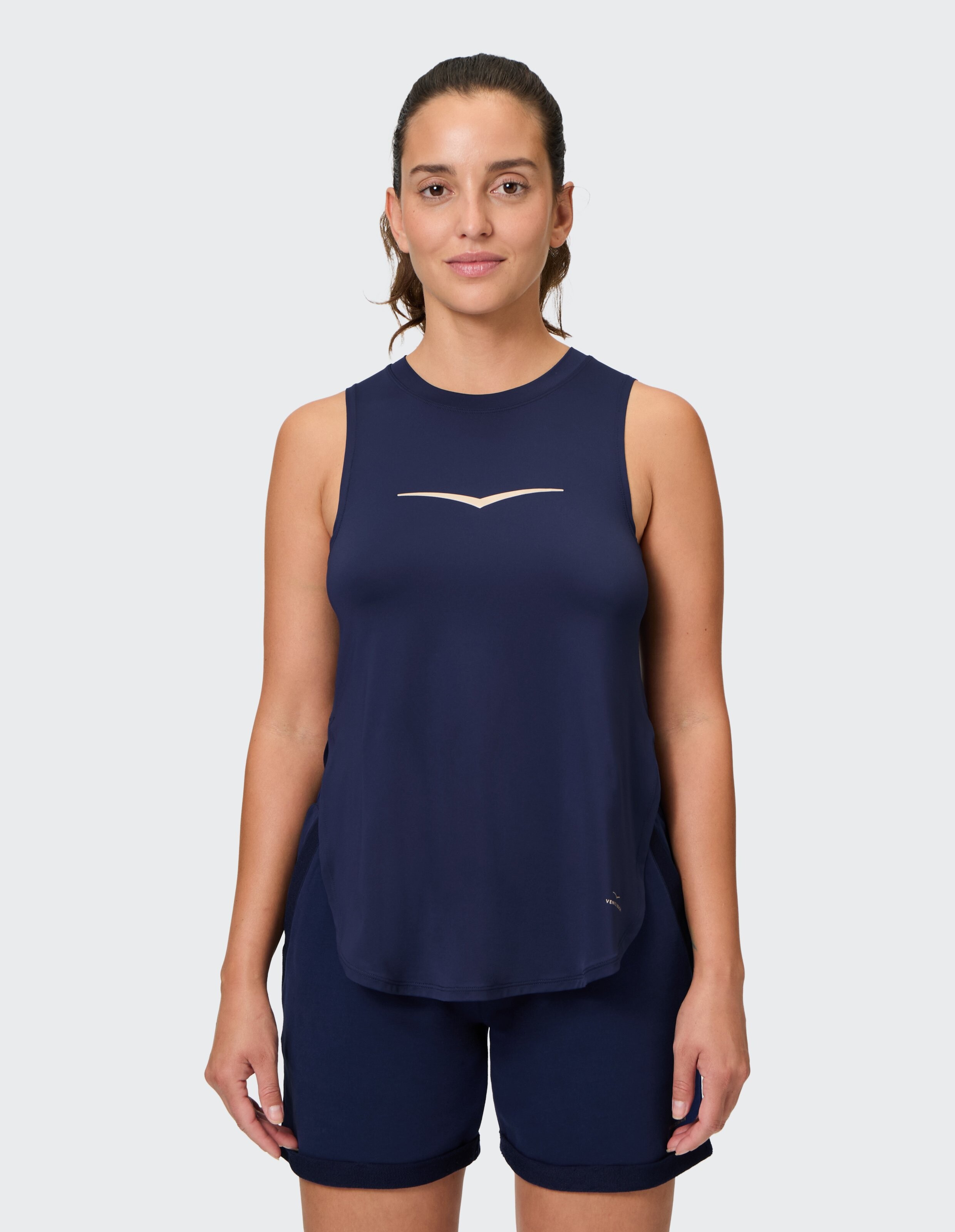 Frau trägt ein marineblaues ärmelloses Tanktop mit dezentem Logo für lässige Loungewear.