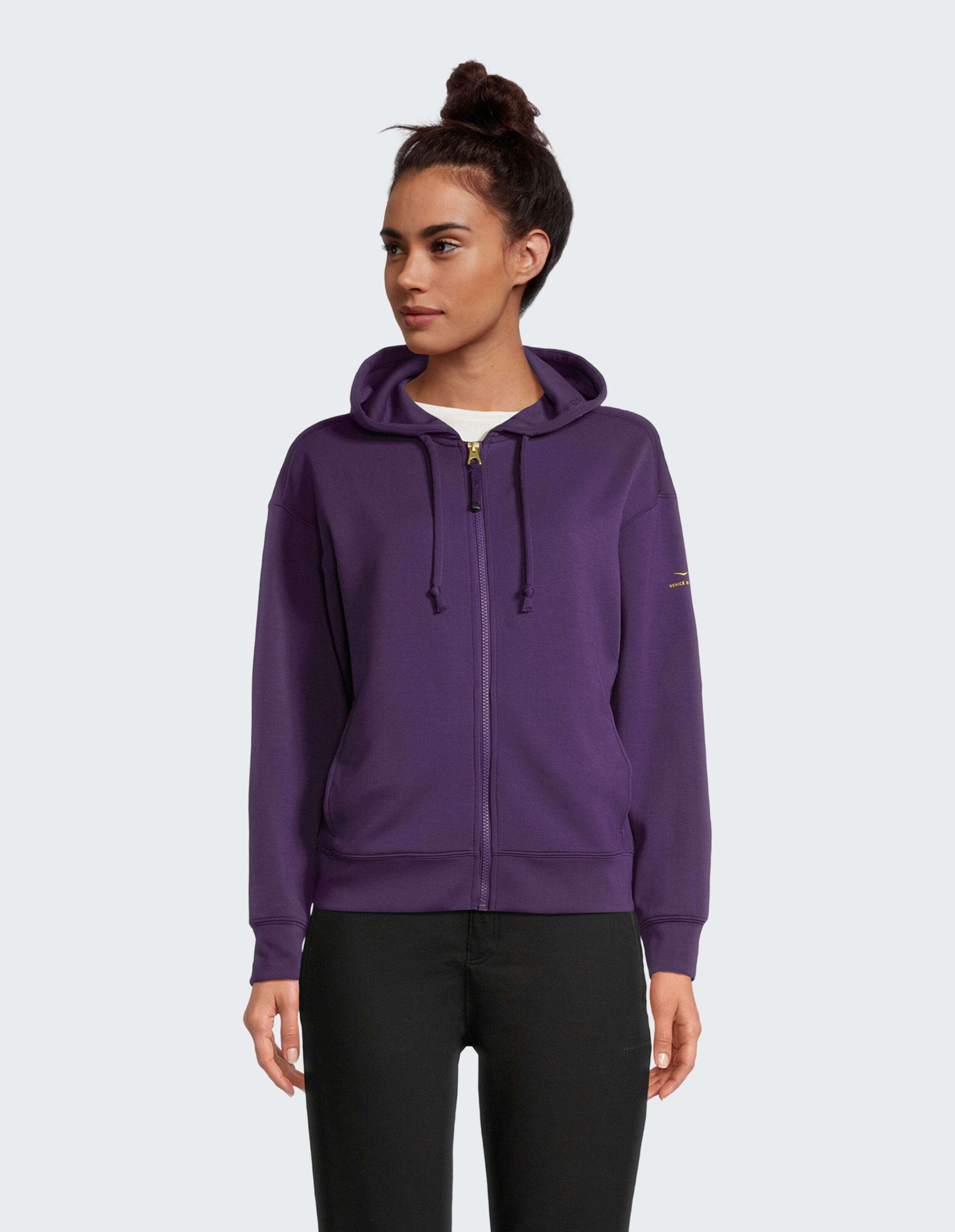 Frau trägt einen kuscheligen lila Kapuzenpullover mit Reißverschluss, perfekt für lässige Loungewear.