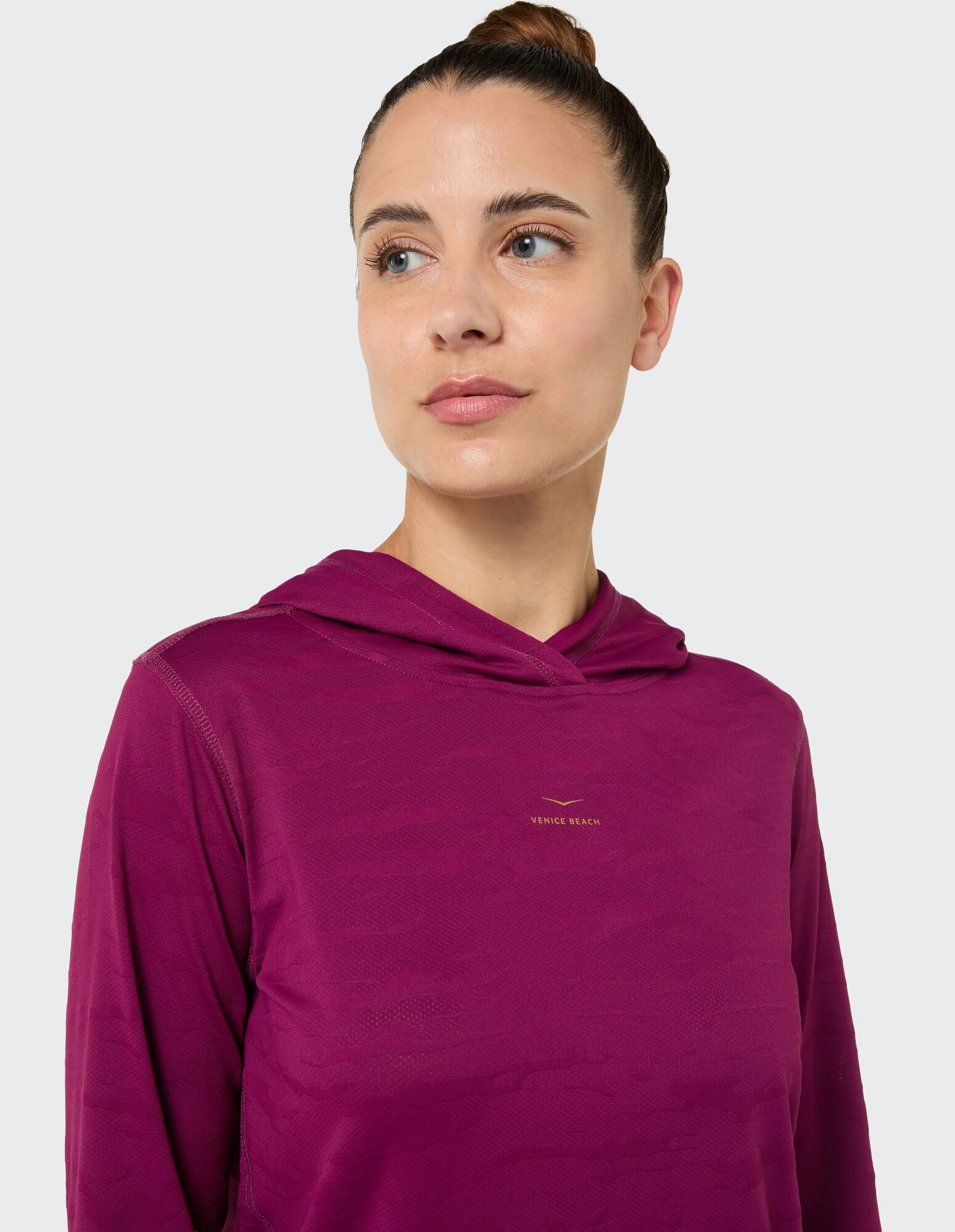 Frau in einem kuscheligen lila Kapuzenpullover mit dezentem Muster, ideal für Freizeitkleidung.