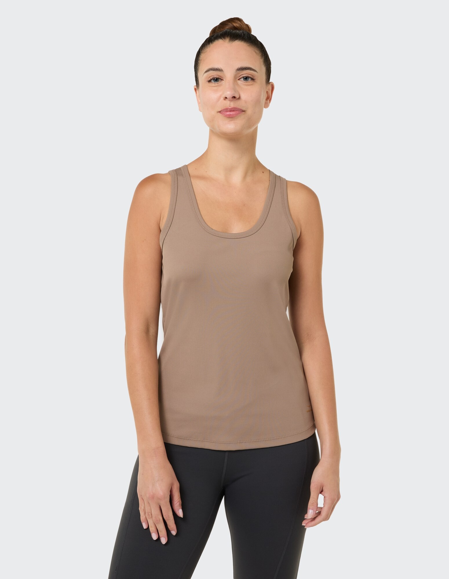 Frau trägt ein braunes Tanktop, ideal für Freizeitkleidung und zum Faulenzen.