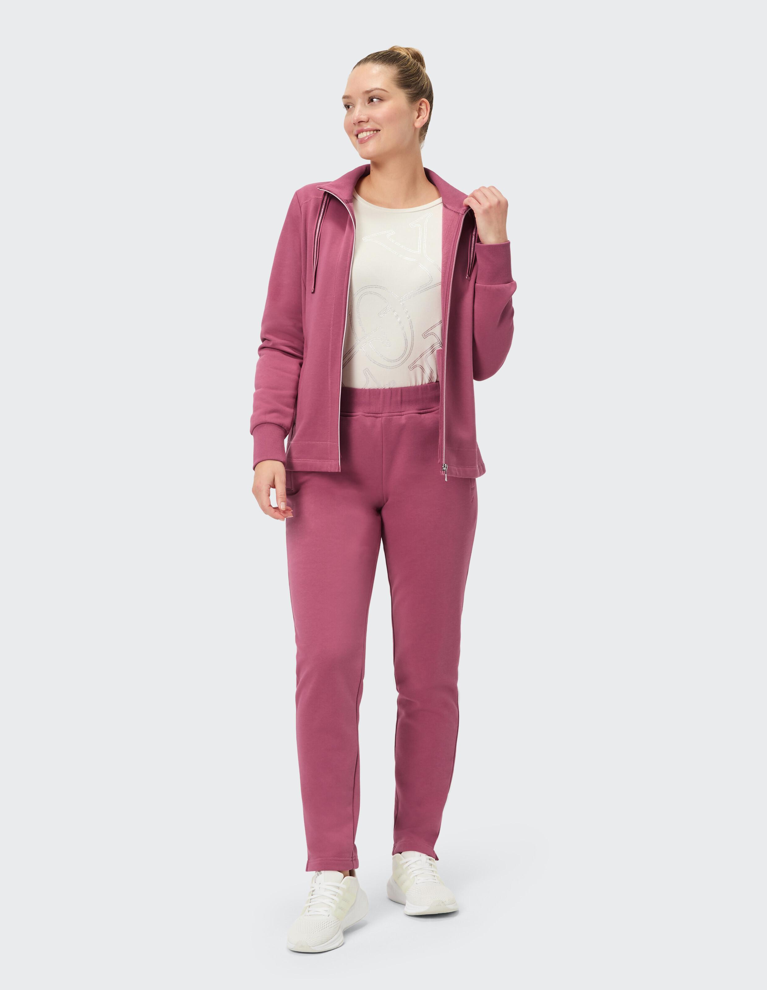 Frau in einem gemütlichen rosafarbenen Trainingsanzug, perfekt für Freizeitkleidung und Faulenzen.