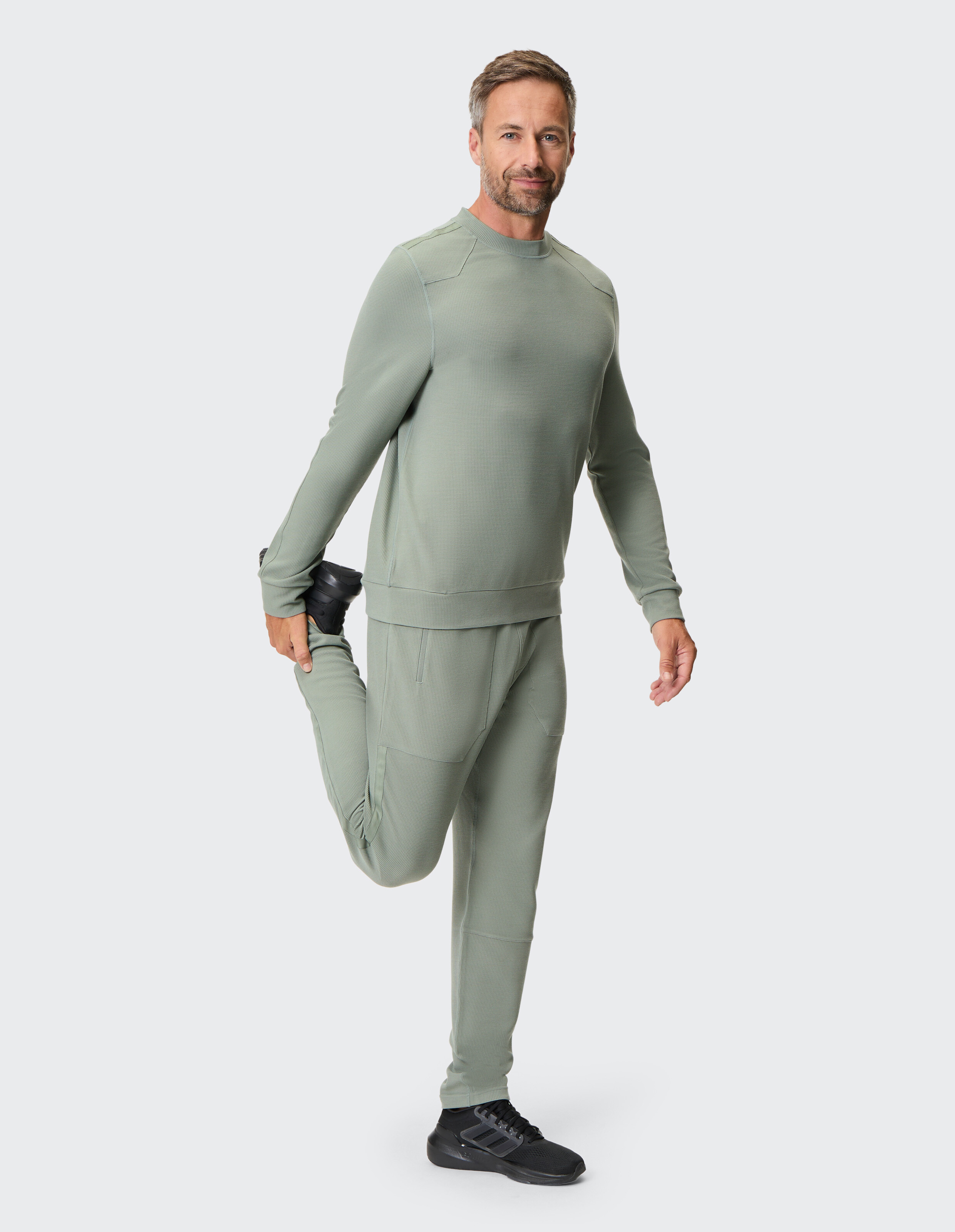 Grauer Pullover mit Rundhalsausschnitt und langen Ärmeln, gefertigt aus strukturiertem Stoff mit dezentem, geometrischem Muster.