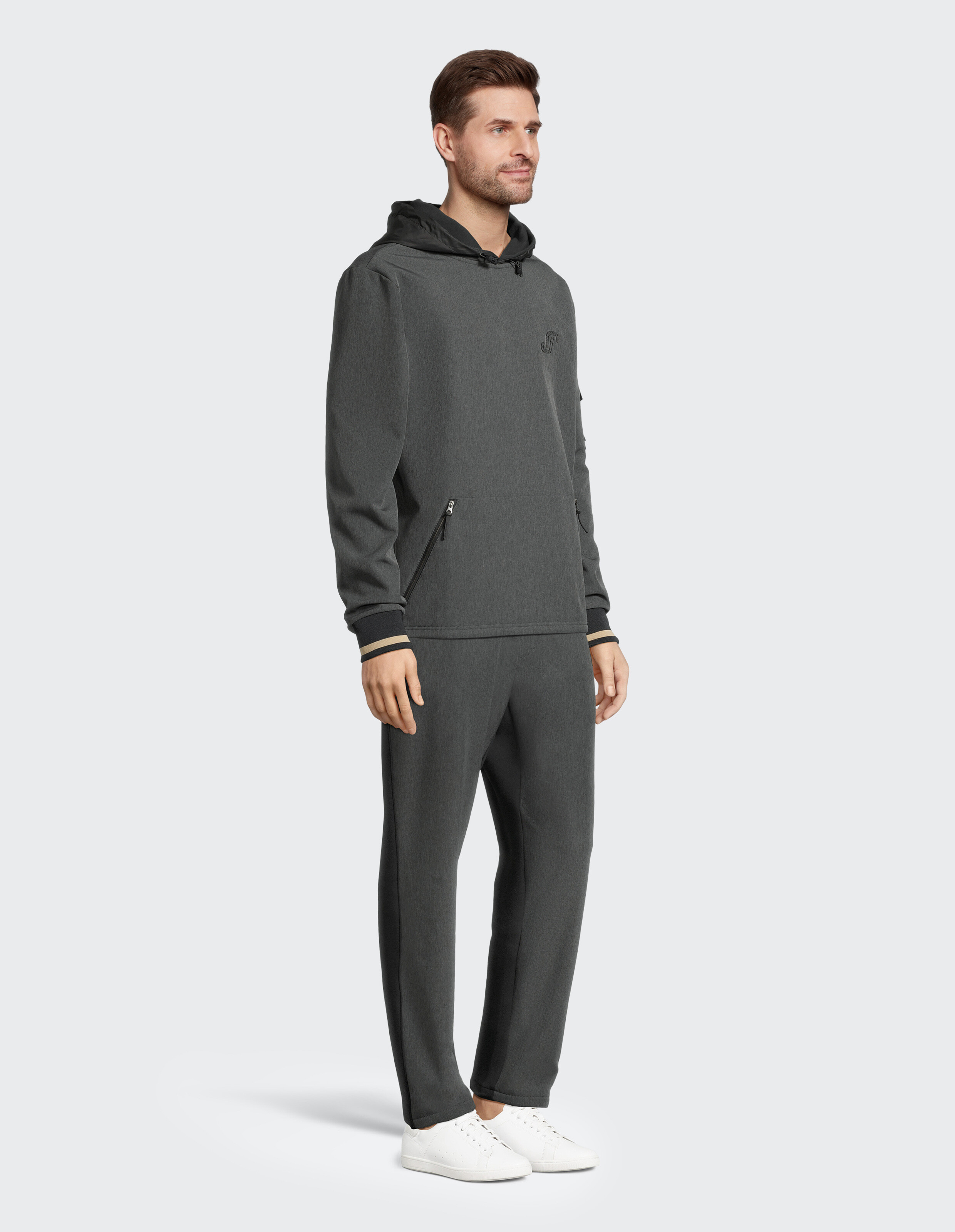 Mann trägt einen dunkelgrauen, lässigen Kapuzenpullover und eine passende Jogginghose für einen bequemen Lounge-Look.