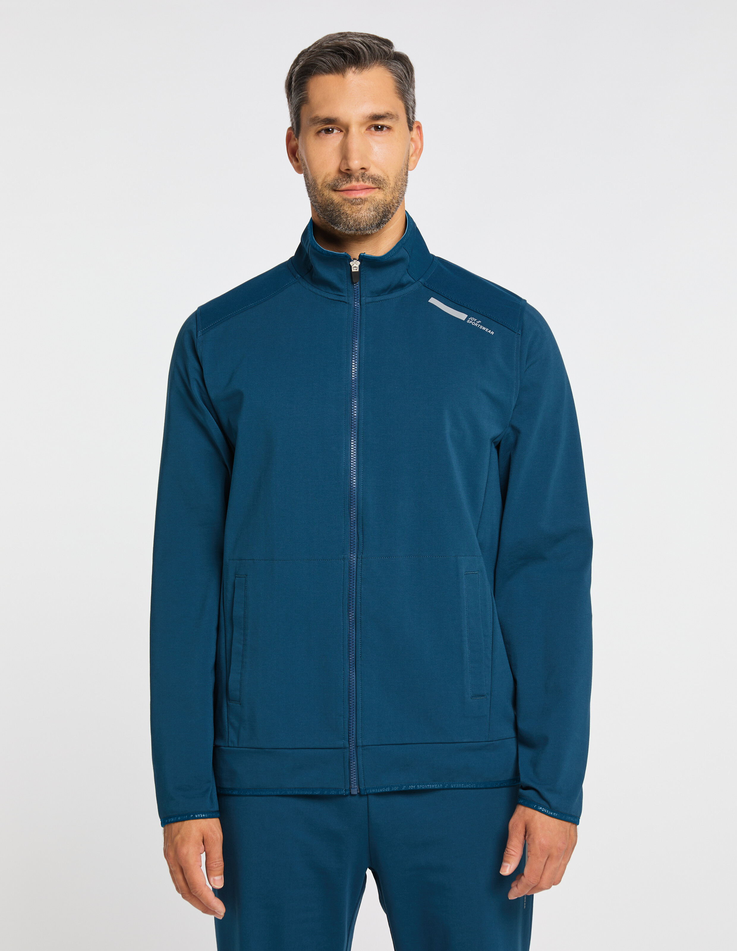 Blaue Jacke mit durchgehendem Reißverschluss, hohem Kragen und zwei seitlichen Taschen, ideal für sportliche Aktivitäten.