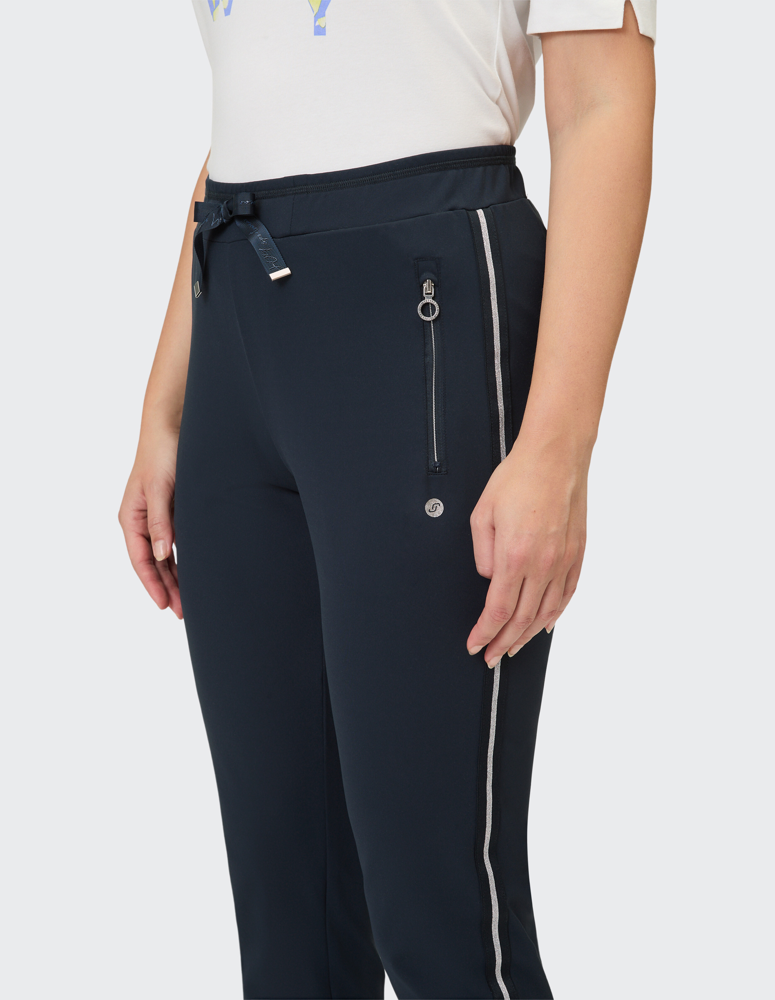 Nahaufnahme einer marineblauen Freizeithose mit seitlichen Reißverschlüssen und Kordelzug in der Taille.
