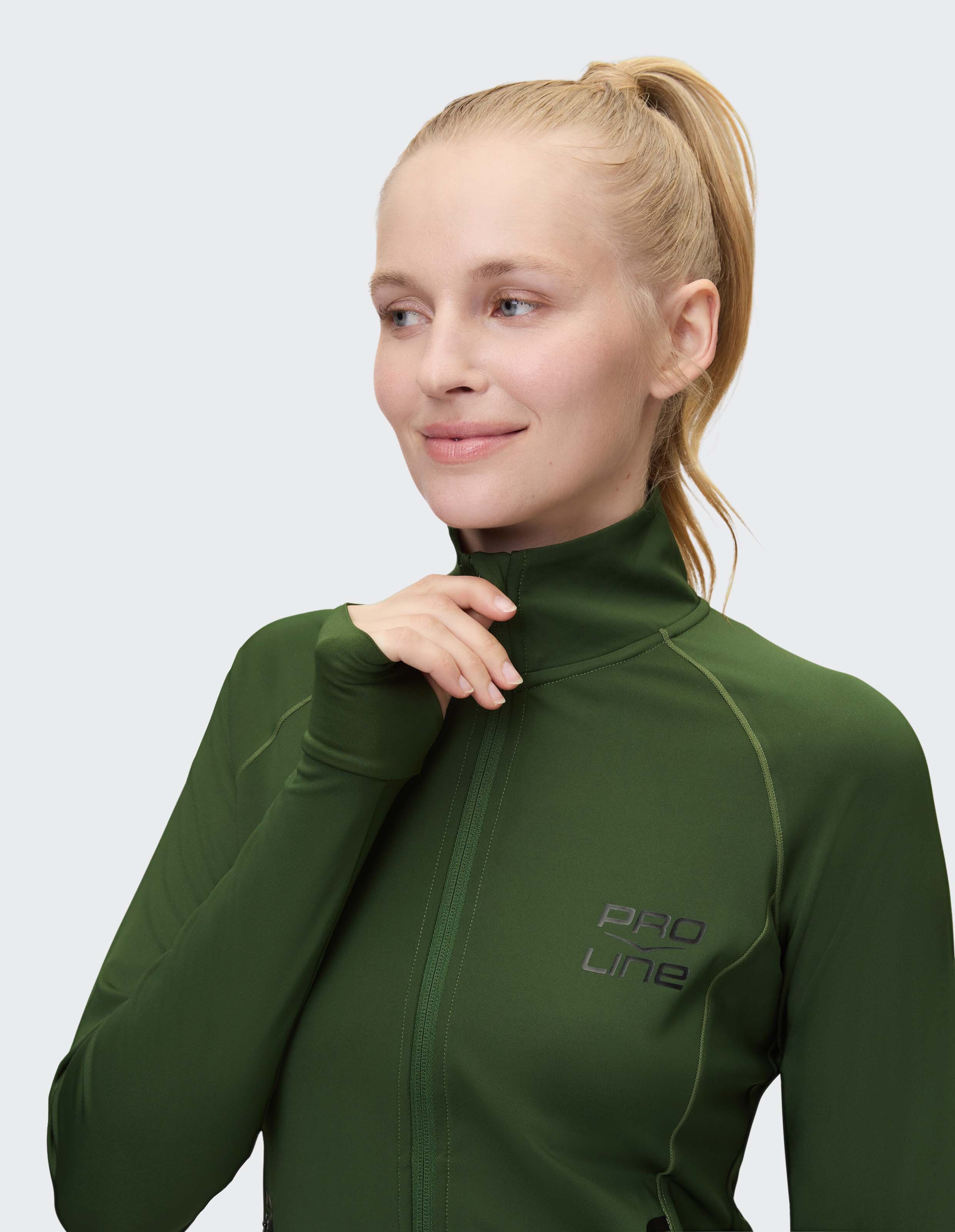 Frau trägt eine grüne Sportjacke mit Reißverschluss und Daumenlöchern für Freizeitkleidung.
