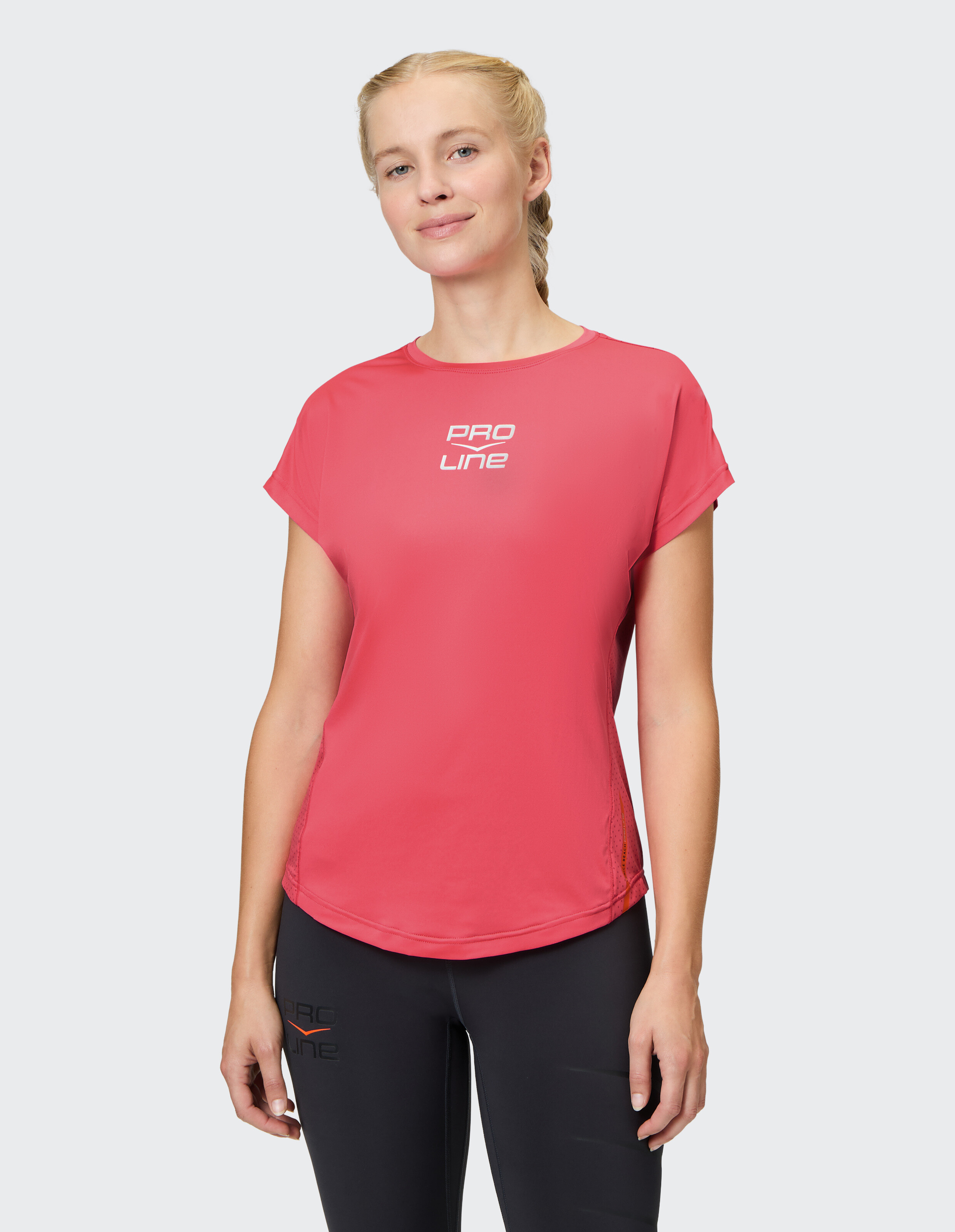 Frau trägt ein rosafarbenes, kurzärmliges Sportshirt mit Pro Line-Branding.