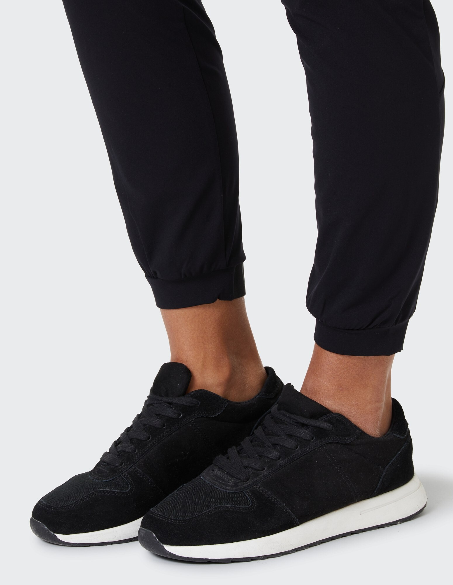 Schwarze Freizeit-Sneaker gepaart mit einer schwarzen Jogginghose für einen stilvollen Look.