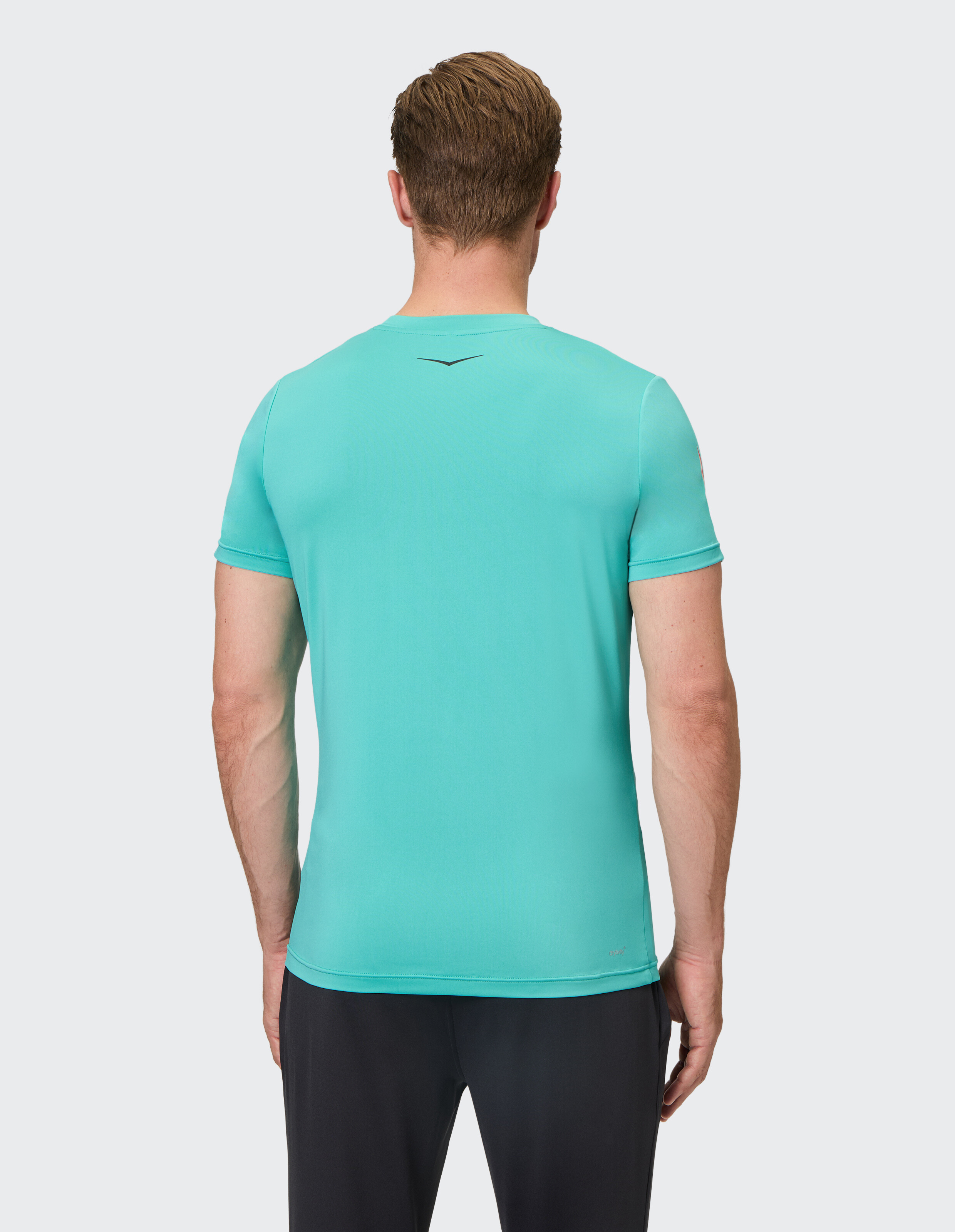 Mann trägt ein türkisfarbenes, kurzärmliges Freizeit-T-Shirt, Rückansicht, Studioumgebung.