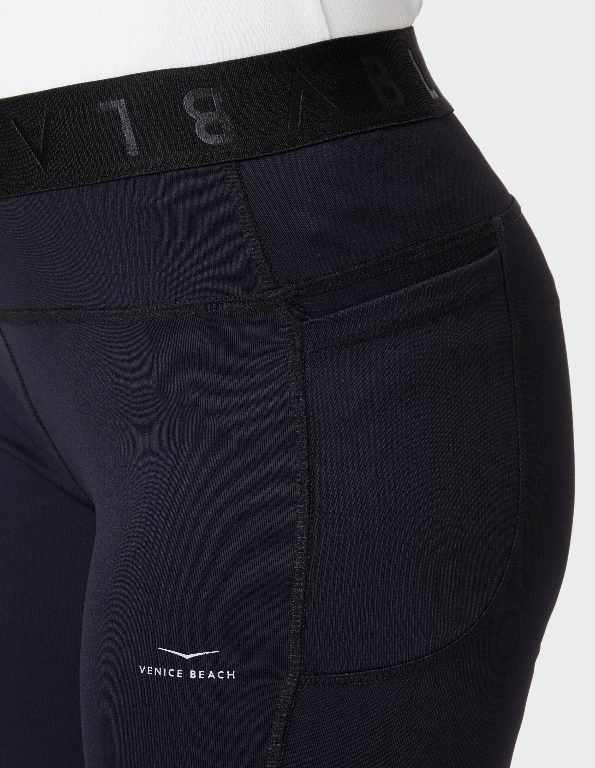 Nahaufnahme einer schwarzen Leggings mit hohem Bund und Venice Beach-Logo.