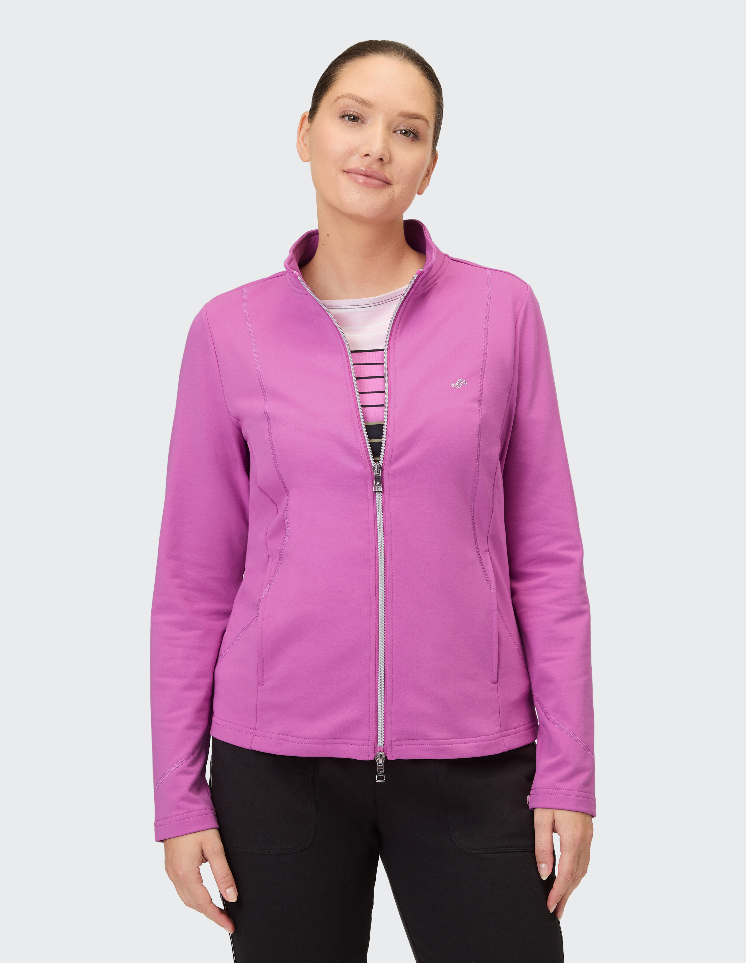 Frau trägt eine rosa Jacke mit Reißverschluss, perfekt für Freizeitausflüge oder zum Faulenzen.